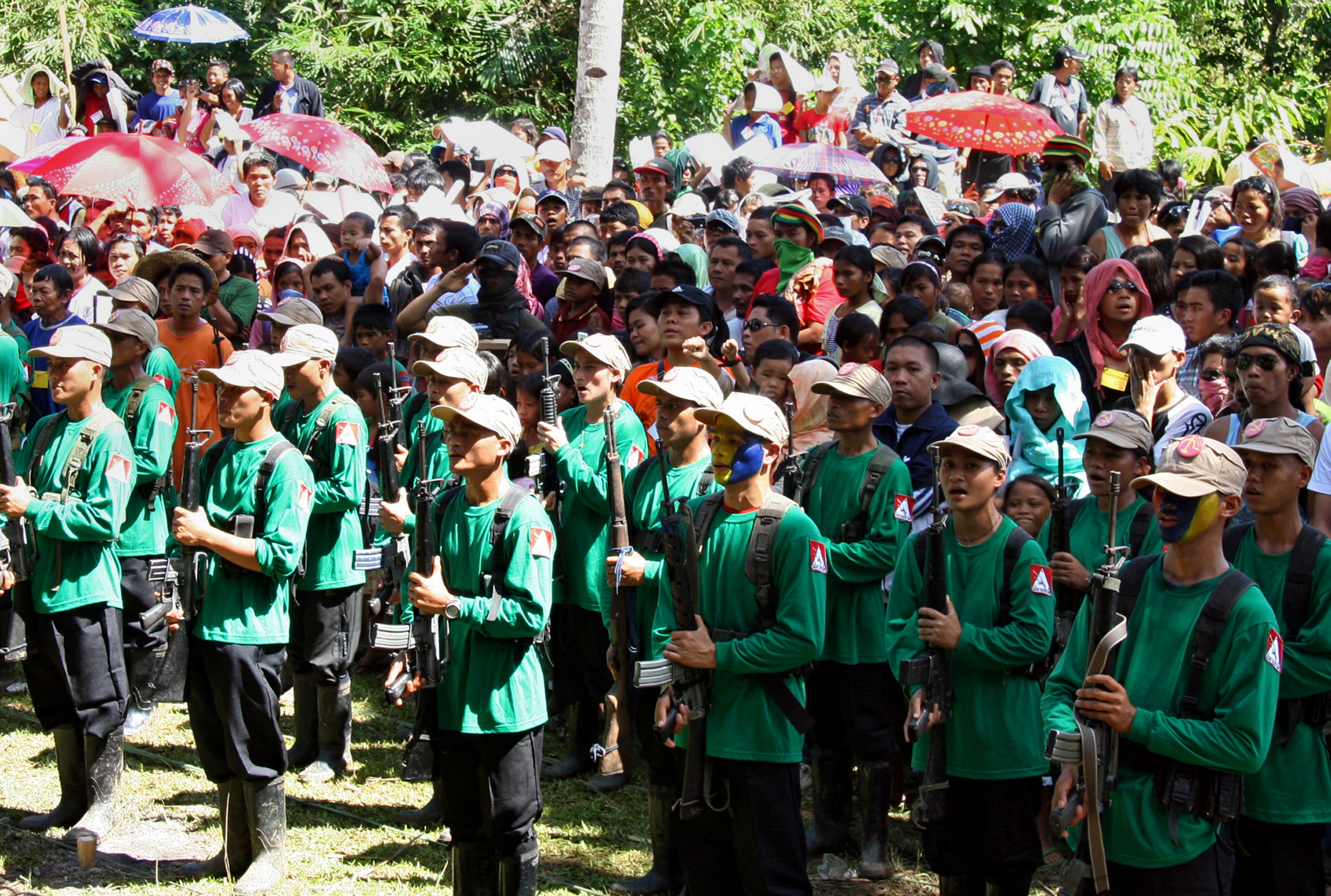 In this file photograph taken on December 26, 2010, New People's Army (NPA) guerrillas attend a ceremony to celebrate the 42nd founding anniversary of the Communist Party of the Philippines, at a remote village in the southern island of Mindanao. The Philippine government and communist guerrillas have agreed to ceasefires from August 20, both sides said, ahead of crucial peace talks next week to end one of Asia's longest insurgencies. / AFP PHOTO / STRINGER / XGTY