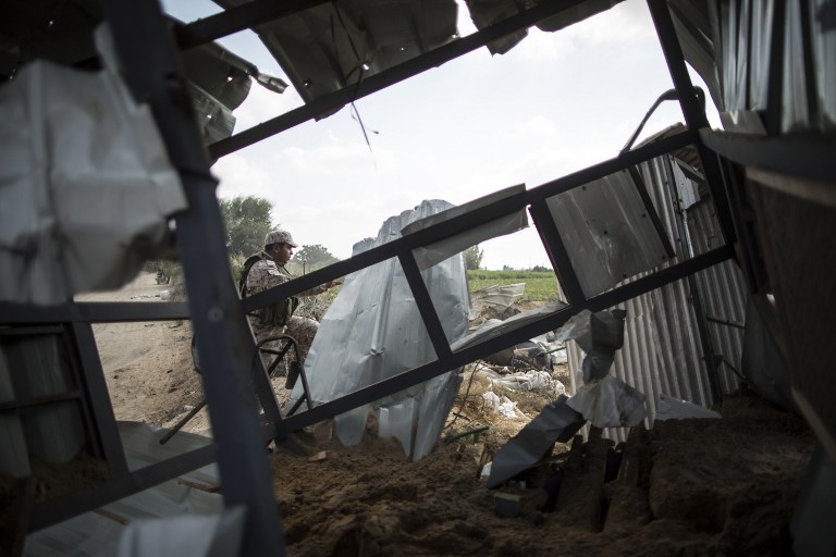 A Palestinian militant of the Islamic Jihad movement inspects the rubble of a makeshift dwelling on August 22, 2016 in Beit Lahia in the northern Gaza Strip, following an Israeli airstrike the day before that targeted Hamas positions in the Gaza Strip in response to a rocket fired from the Palestinian enclave hits the Israeli city of Sderot.  Israel targeted Hamas positions in the Gaza Strip by air and with tank fire on August 21, 2016 after a rocket fired from the Palestinian enclave crashed into the Israeli city of Sderot. Palestinian security sources in the territory said several targets in northen Gaza were struck by Israeli fire, and that a reservoir in Beit Hanun was destroyed. Witnesses said a base of Hamas's military wing the Ezzedine Al-Qassam Brigades, in nearby Beit Lahia, was also hit. / AFP PHOTO / MAHMUD HAMS