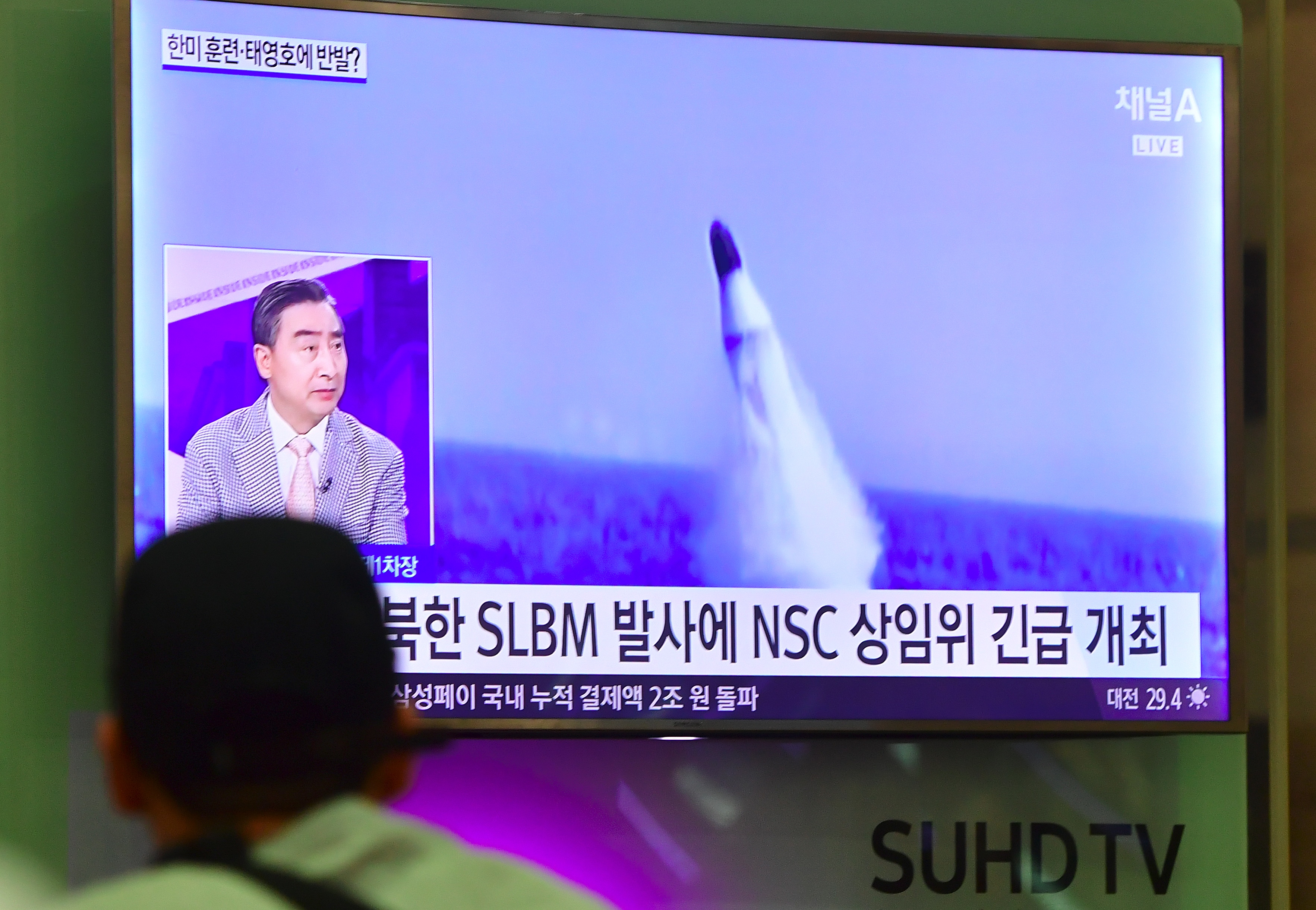 A man watches a television news showing file footage of a North Korean missile launch at Incheon airport, west of Seoul, on August 24, 2016. North Korea test-fired a submarinelaunched ballistic missile on August 24, days after threatening a nuclear strike in retaliation at the start of large-scale South Korea-US military exercises. / AFP PHOTO / JUNG YEON-JE