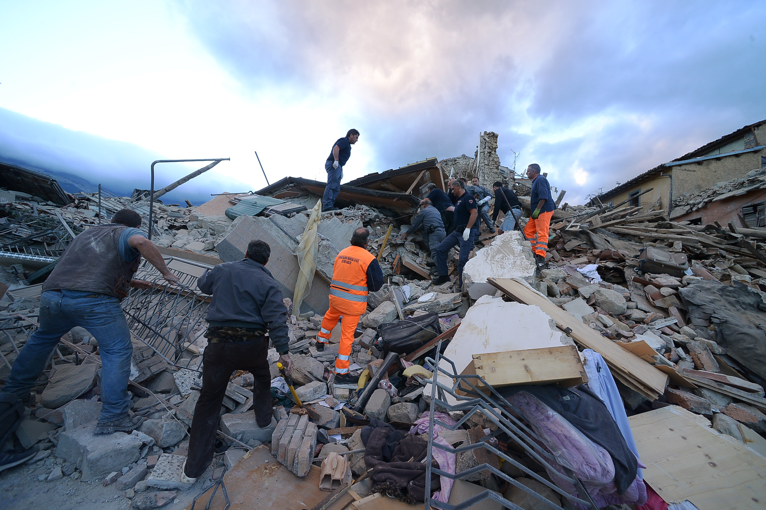 Resucers search for victims in damaged buildings after a strong heartquake hit Amatrice on August 24, 2016. Central Italy was struck by a powerful, 6.2-magnitude earthquake in the early hours, which has killed at least three people and devastated dozens of mountain villages. Numerous buildings had collapsed in communities close to the epicenter of the quake near the town of Norcia in the region of Umbria, witnesses told Italian media, with an increase in the death toll highly likely. / AFP PHOTO / FILIPPO MONTEFORTE