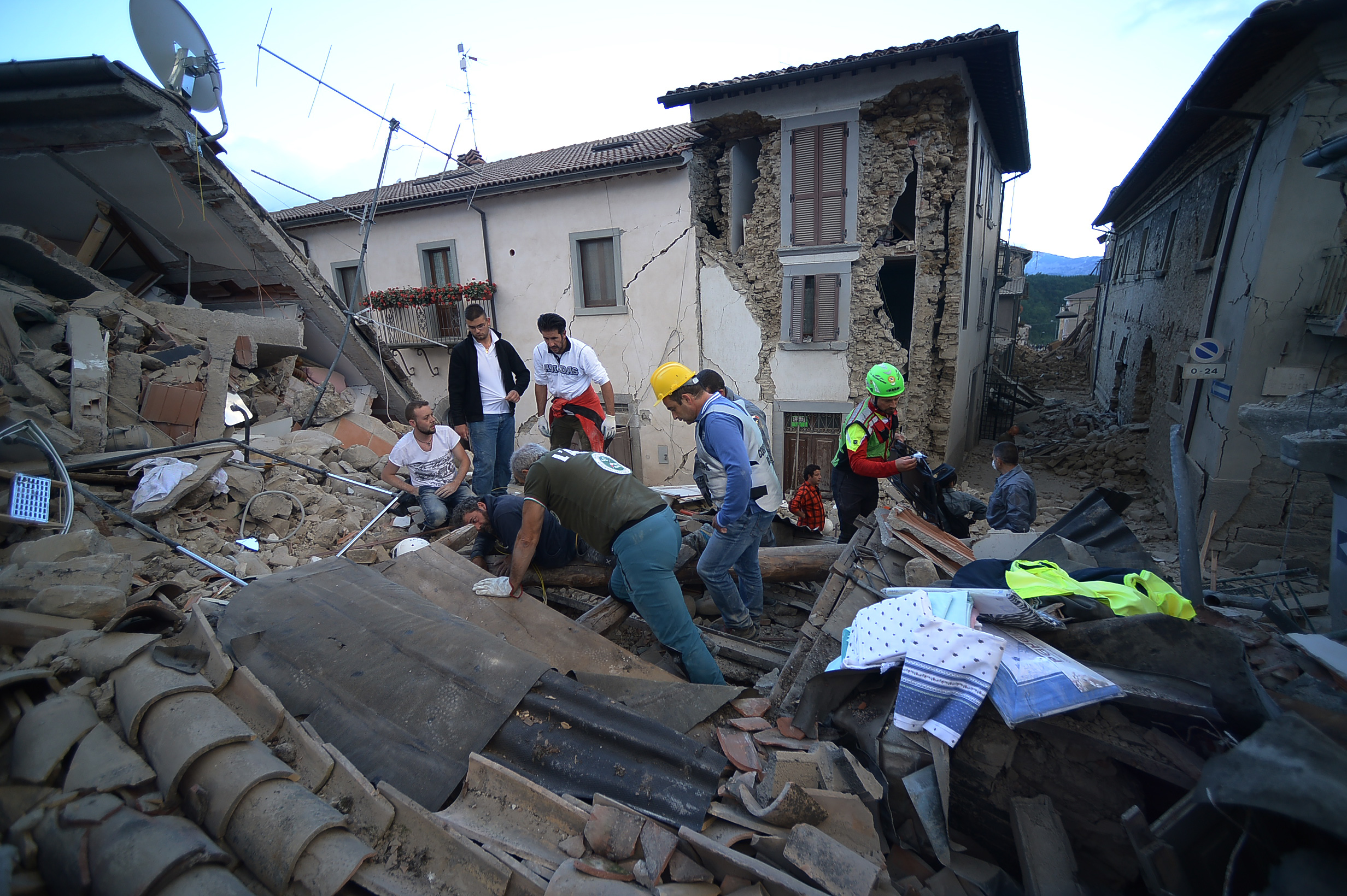 Rescuers search for victims among damaged buildings after a strong heartquake hit Amatrice on August 24, 2016. Central Italy was struck by a powerful, 6.2-magnitude earthquake in the early hours, which has killed at least three people and devastated dozens of mountain villages. Numerous buildings had collapsed in communities close to the epicenter of the quake near the town of Norcia in the region of Umbria, witnesses told Italian media, with an increase in the death toll highly likely. / AFP PHOTO / FILIPPO MONTEFORTE
