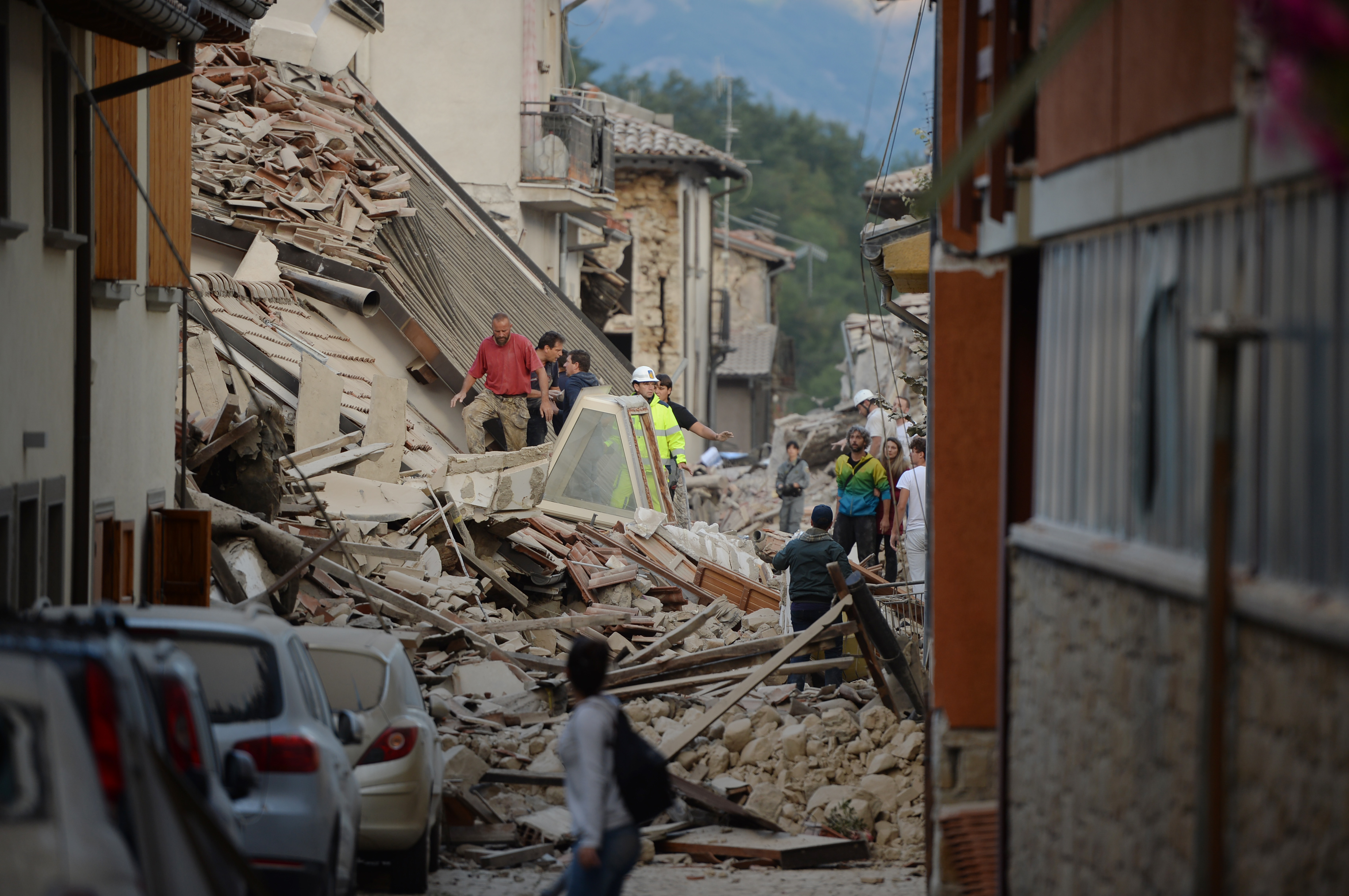 Rescuers and residents search for victim among damaged buildings after a strong heartquake hit Amatrice on August 24, 2016. Central Italy was struck by a powerful, 6.2-magnitude earthquake in the early hours, which has killed at least three people and devastated dozens of mountain villages. Numerous buildings had collapsed in communities close to the epicenter of the quake near the town of Norcia in the region of Umbria, witnesses told Italian media, with an increase in the death toll highly likely. / AFP PHOTO / FILIPPO MONTEFORTE
