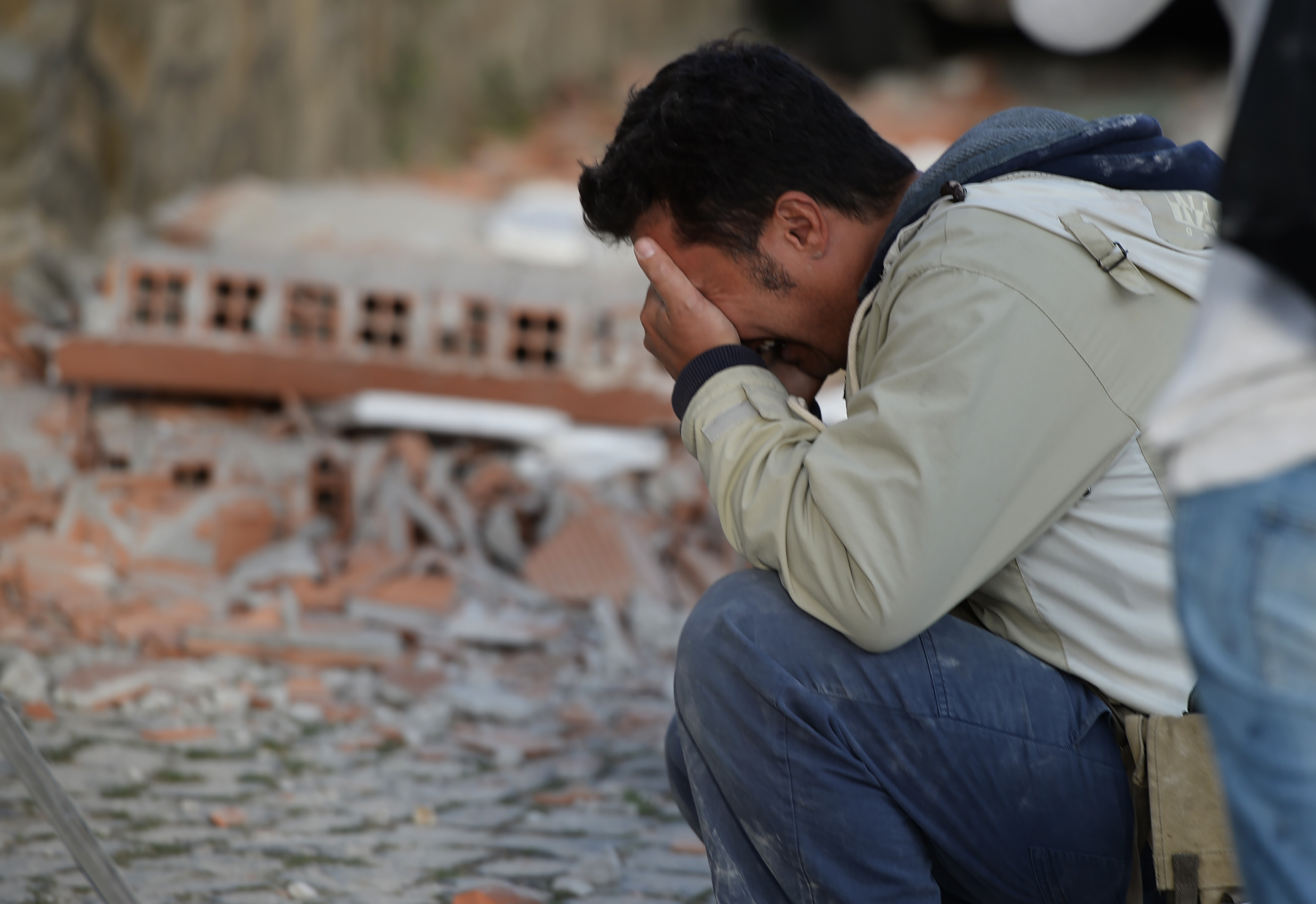A man reacts after a strong heathquake hit Amatrice on August 24, 2016. Central Italy was struck by a powerful, 6.2-magnitude earthquake in the early hours, which has killed at least three people and devastated dozens of mountain villages. Numerous buildings had collapsed in communities close to the epicenter of the quake near the town of Norcia in the region of Umbria, witnesses told Italian media, with an increase in the death toll highly likely. / AFP PHOTO / FILIPPO MONTEFORTE