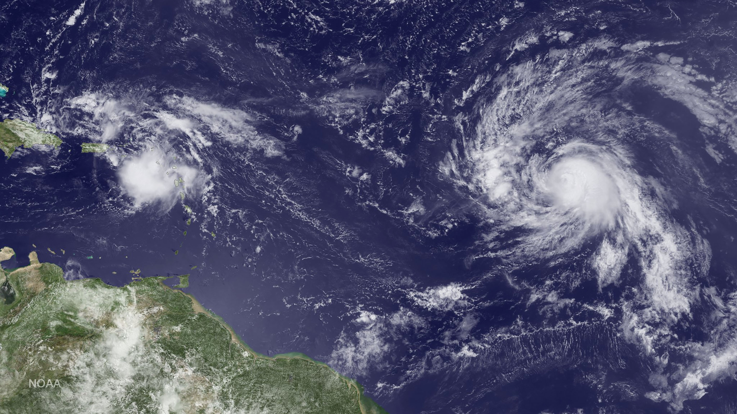 This NOAA image taken by GOES East on August 24, 2016, shows weather disturbance Invest 99L to the west near Puerto Rico and Tropical Storm Gaston to the east. According to NOAA's  National Hurricane Center, Tropical Storm Gaston could reach hurricane strength today, however the storm could move into environmental conditions that might weaken it temporarily. The current forecast shows the storm pushing through these conditions in roughly 72 hours and re-strengthening, perhaps significantly.  / AFP PHOTO / NOAA / HO / RESTRICTED TO EDITORIAL USE - MANDATORY CREDIT "AFP PHOTO / NOAA" - NO MARKETING NO ADVERTISING CAMPAIGNS - DISTRIBUTED AS A SERVICE TO CLIENTS