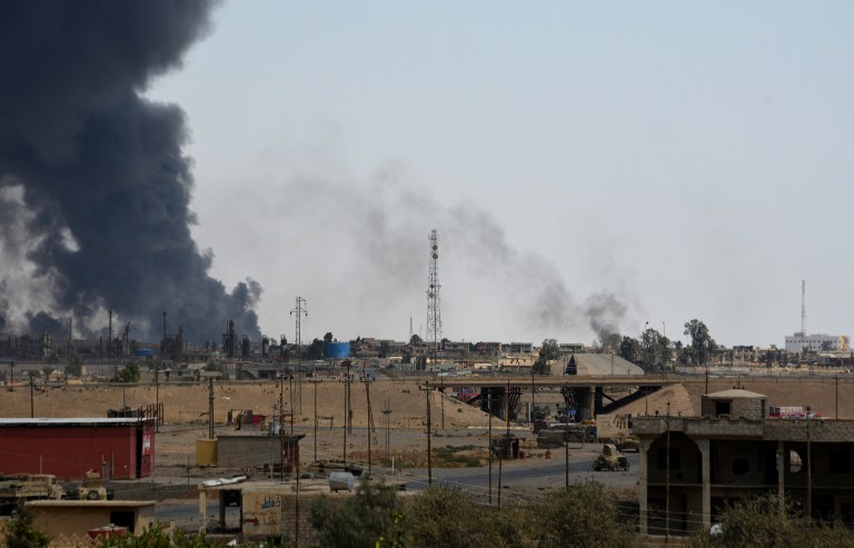 A general view shows smoke billowing from the Qayyarah on August 24, 2016, as Iraqi forces took key positions in the centre of the city, officials said, on the second day of an operation to recapture the northern town from jihadists. Qayyarah lies on the western bank of the Tigris river, about 60 kilometres (35 miles) south of Mosul, the Islamic State group's last major urban stronghold in Iraq.  / AFP PHOTO / MAHMOUD SALEH