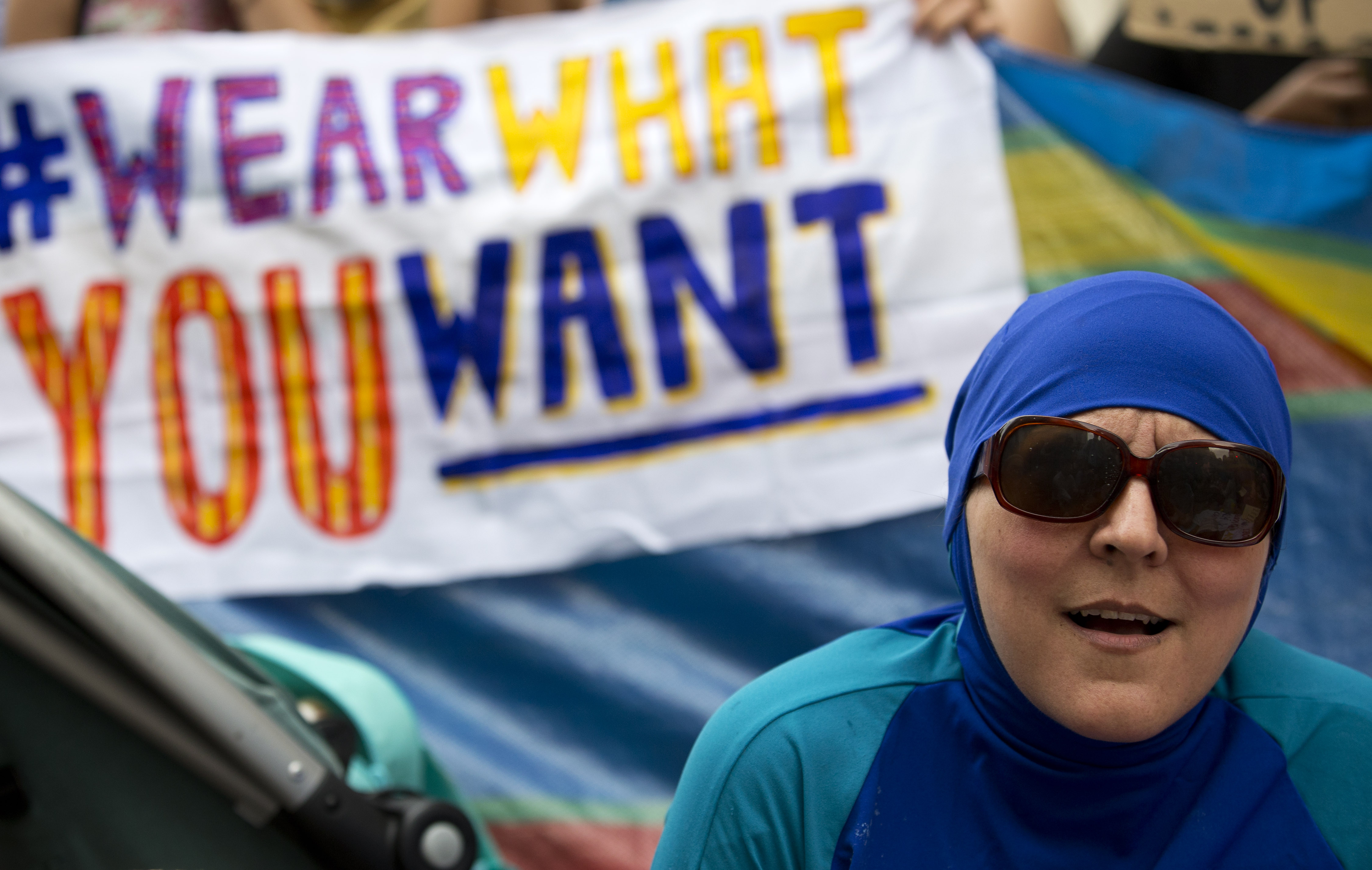 A woman wearing a "Burkini" joins a protest outside the French Embassy in London on August 25, 2016, during a "Wear what you want beach party" to demonstrate against the ban on Burkinis on French beaches and to show solidarity with Muslim women. French Interior Minister Bernard Cazeneuve warned Wednesday against stigmatising Muslims, as a furore over the banning of burkinis grew with the emergence of pictures showing police surrounding a veiled woman on a beach.  Dozens of French towns and villages, mostly on the Cote d'Azur, have banned beachwear that "conspicuously" shows a person's religion -- a measure aimed at the full-body Islamic swimsuit but which has also been used against women wearing long clothes and a headscarf. / AFP PHOTO / JUSTIN TALLIS