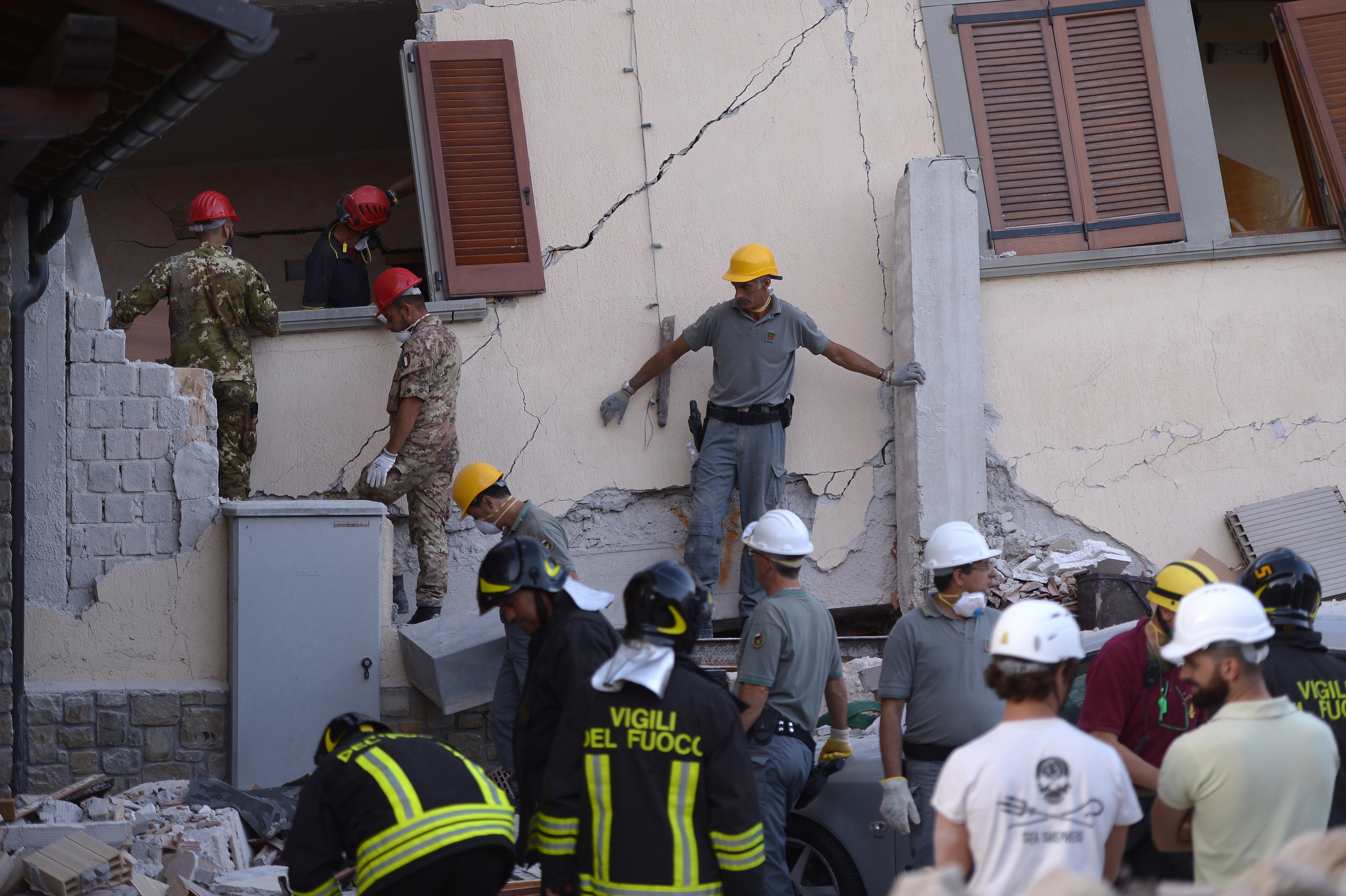 Volunteers assist rescue and emergency services personnel at the damaged Hotel Rome in the central Italian village of Amatrice, on August 25, 2016, a day after a 6.2-magnitude earthquake struck the region killing some 247 people. The death toll from a powerful earthquake in central Italy rose to 247 on August 25, 2016 amid fears many more corpses would be found in the rubble of devastated mountain villages. Rescuers sifted through collapsed masonry in the search for survivors, but their grim mission was clouded by uncertainty about exactly how many people had been staying in communities closest to the epicentre of the quake of August 24.  / AFP PHOTO / FILIPPO MONTEFORTE
