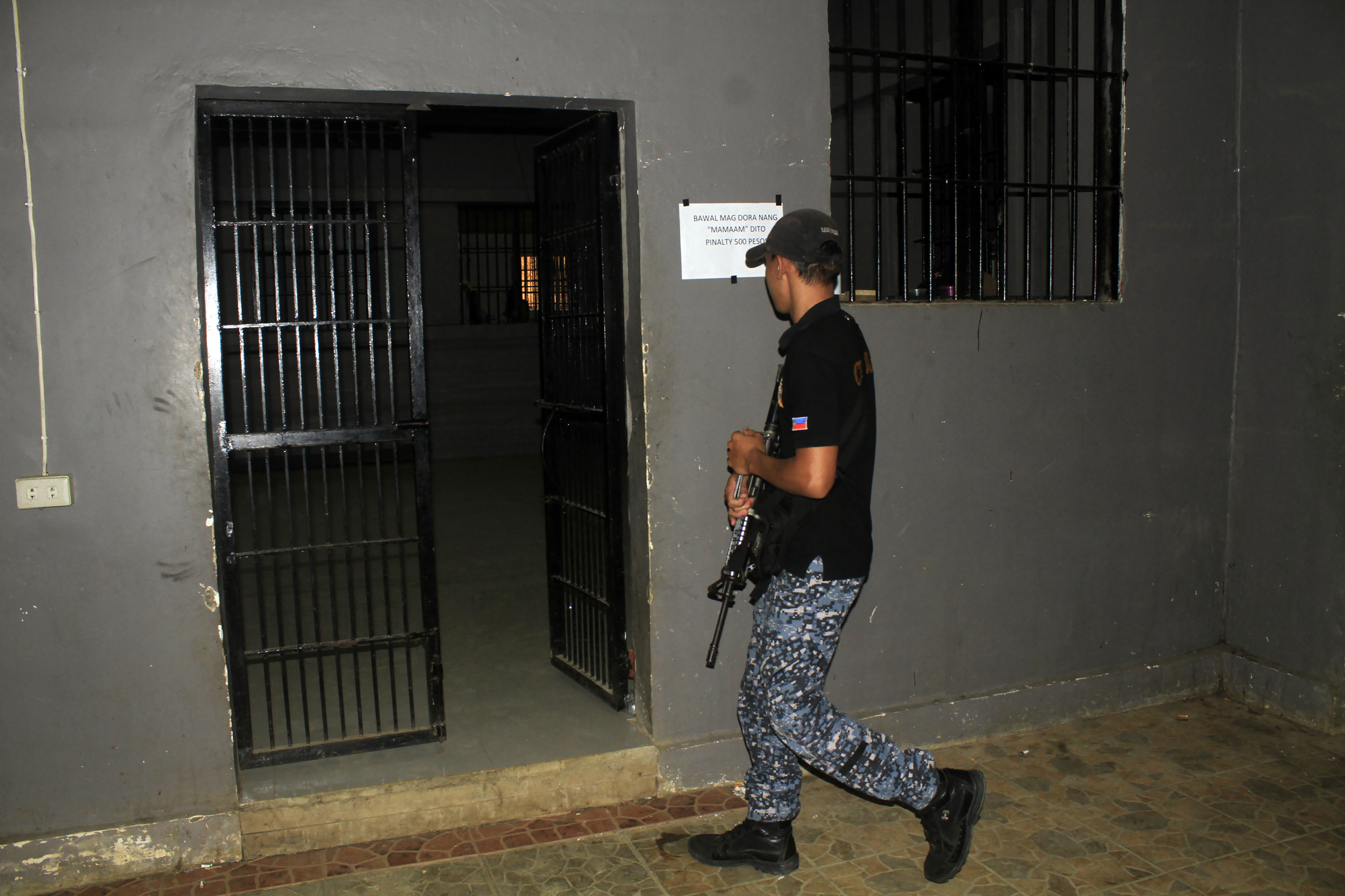 A jail guard walks past an prison cell at the provincial jail in Marawi City, in southern island of Mindanao on August 28, 2016, a day after members of Maute group, a Muslim extremist  inspired by the Islamic State movement, rescued their jailed colleagues. Muslim extremists inspired by the Islamic State movement staged a daring jailbreak in the southern Philippines, freeing 28 detainees in the latest in a series of mass escapes, officials said August 28. / AFP PHOTO / RICHELE UMEL