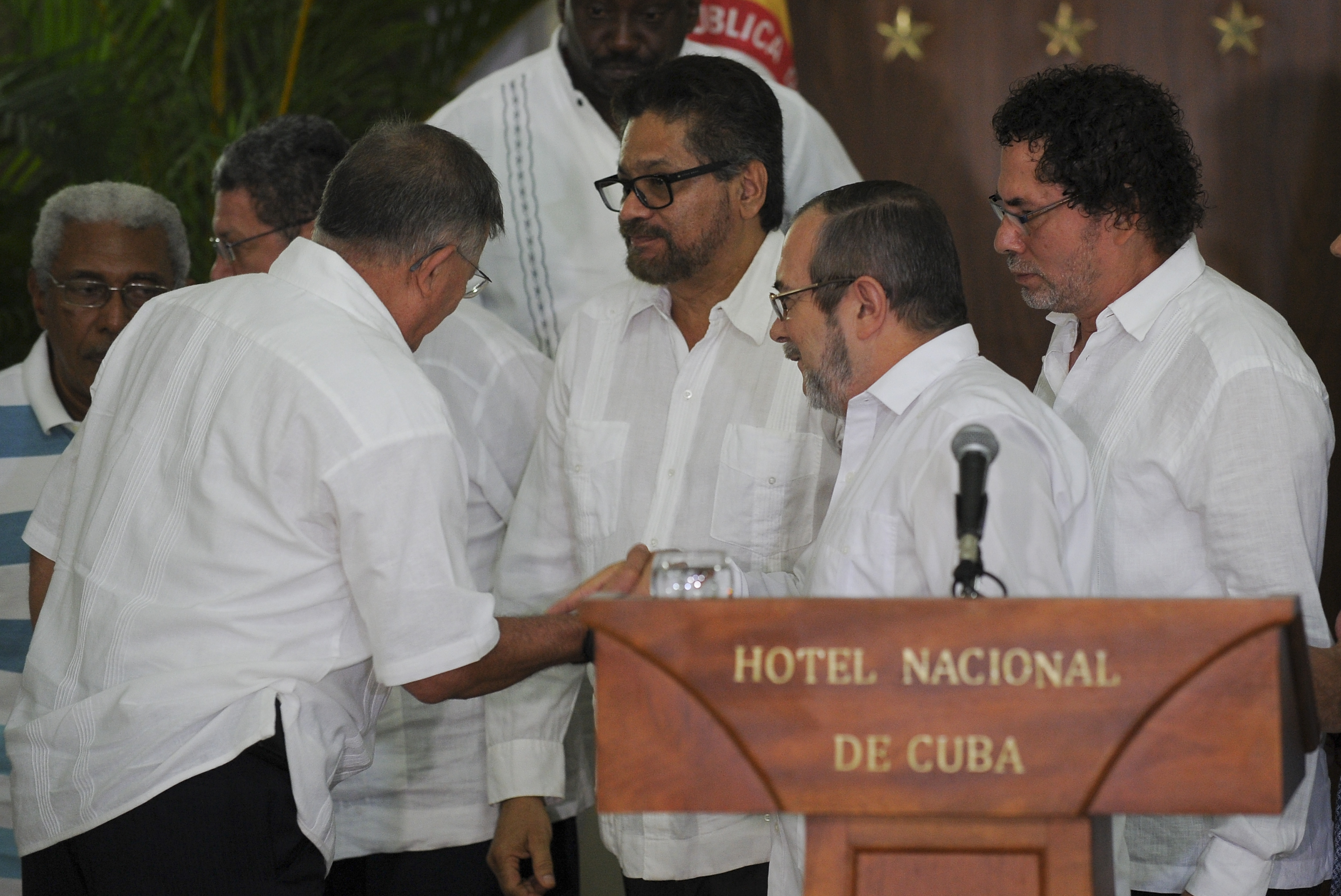 The head of Colombia's FARC guerrilla, Timoleon Jimenez, aka "Timochenko" (2nd-R), greets commanders Rodrigo Granda (R), Ivan Marquez (C) and Pastor Alape (R) during a press conference in Havana on  August 28, 2016.  Colombia's FARC rebel force ordered a definitive ceasefire late Sunday as part of an accord to end 52 years of conflict with the government. / AFP PHOTO / YAMIL LAGE