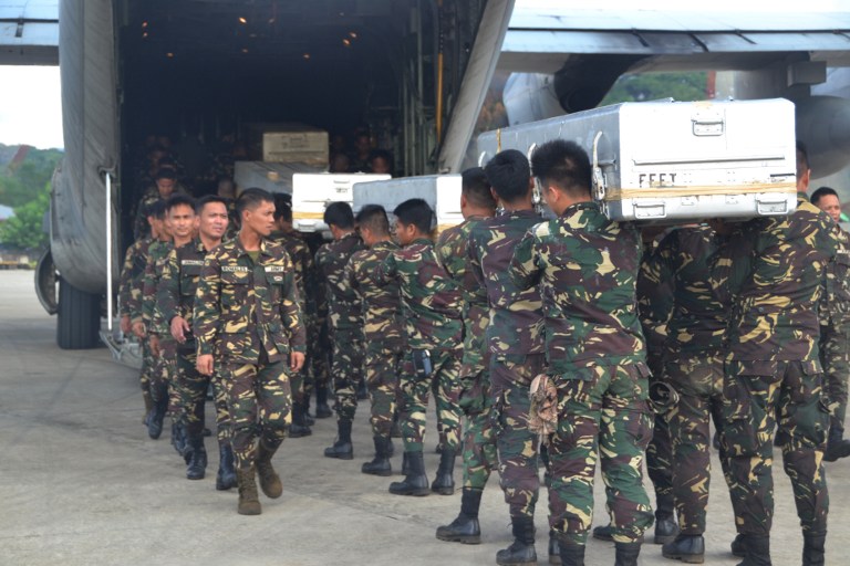 Philippine soldiers carry caskets containing bodies of colleagues, killed in an encounter with Muslim extremist Abu Sayyaf group, into a C-130 cargo plane at Jolo airport in Sulu province on the island of Mindanao, on August 30, 2016. Fighters of the Muslim extremist Abu Sayyaf group killed 15 soldiers as they were carrying out President Rodrigo Duterte's order to wipe out the feared group, officials said on August 30. / AFP PHOTO / STR