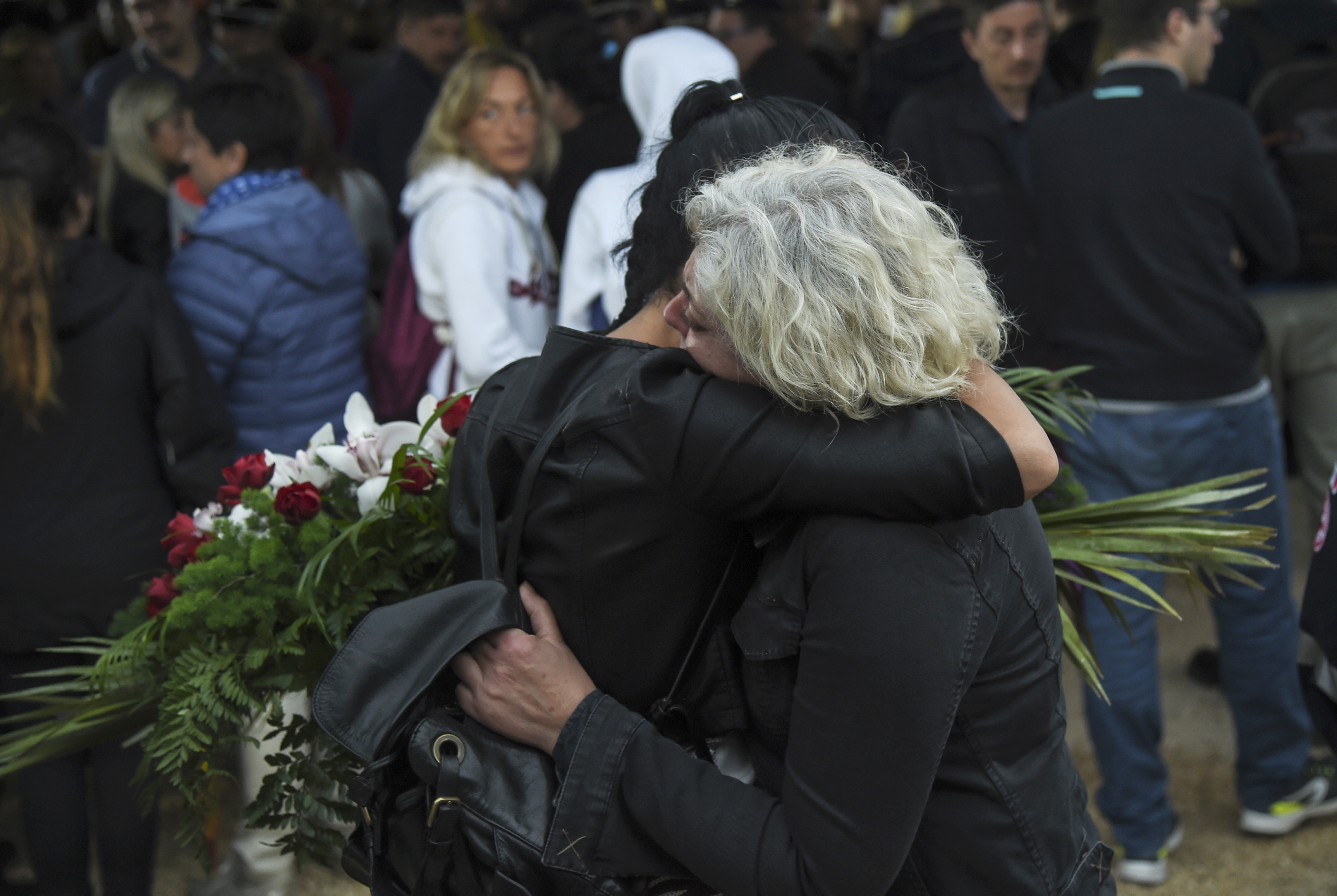 Relatives mourn during a funeral service for victims of the recent earthquake in Amatrice, central Italy, on August 30, 2016. The deadly earthquake brought devastation on August 26 to a string of mountain villages in a remote area straddling the Umbria, Marche and Lazio regions. Nearly 300 people died in the quake and hundreds more were injured, and although rescue efforts were winding down, officials warned it was feasible there are still a dozen or so bodies under the rubble. / AFP PHOTO / ANDREAS SOLARO
