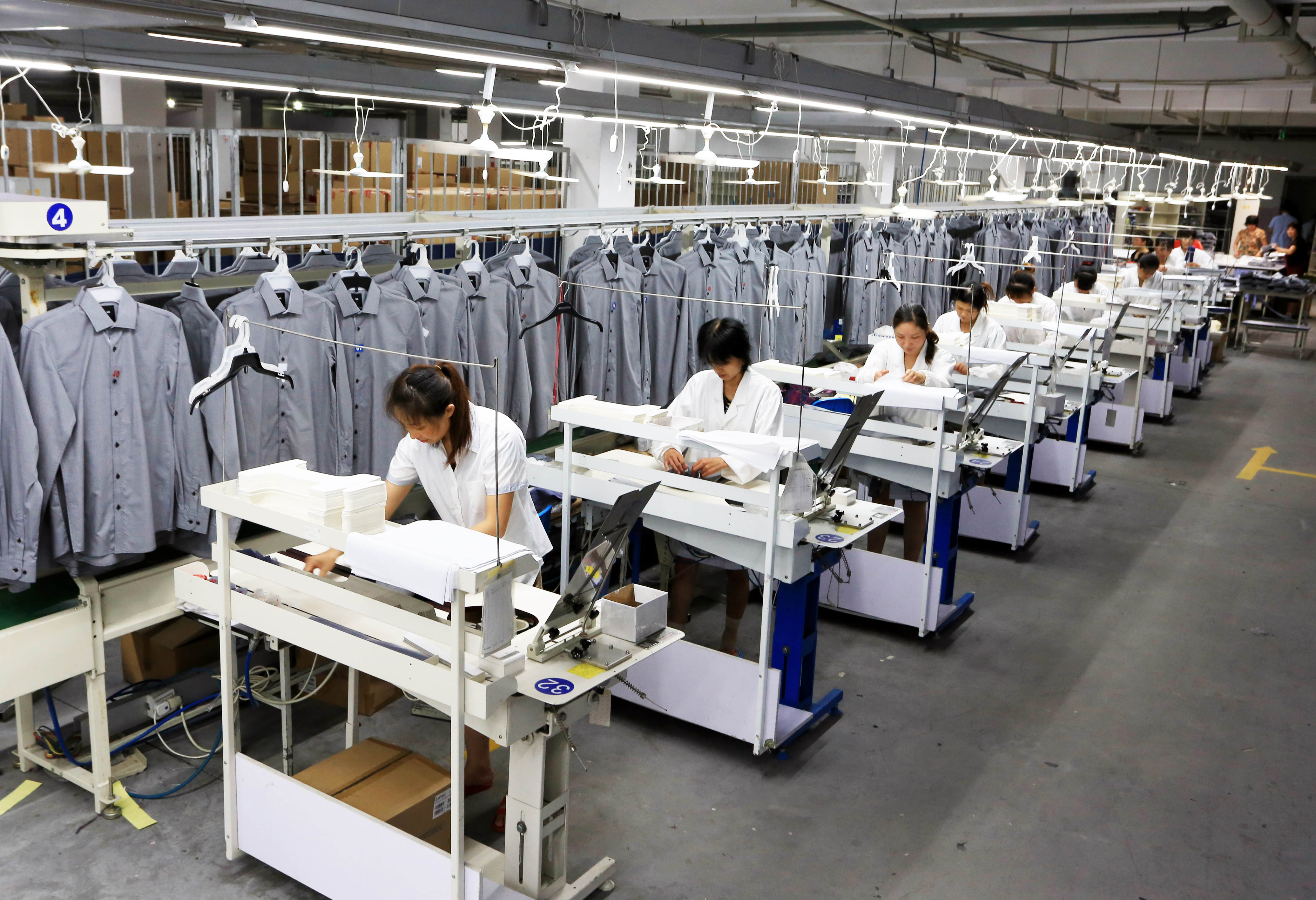 This photo taken on August 29, 2016 shows Chinese workers making shirts at a spinnery in Nantong, east China's Jiangsu province. G20 leaders will meet in China this weekend in a climate of economic uncertainty and sluggish albeit relatively steady growth -- but the absence of an urgent crisis means the forum will be short on breakthroughs, analysts say. / AFP PHOTO / STR / China OUT