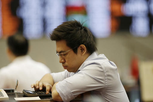 A Filipino trader uses a calculator at the Philippine Stock Exchange in the financial district of Makati, south of Manila, Philippines on Thursday, July 28, 2016. Asian stock benchmarks were mostly lower Thursday as investors digested an upbeat Fed assessment of the U.S. economy that raised the prospect of further rate hikes, while anticipating more stimulus from Japan. (AP Photo/Aaron Favila)