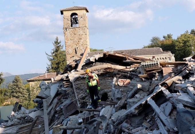 A rescue worker and a dog search among debris following an earthquake in Amatrice, central Italy, August 27, 2016. REUTERS/Ciro De Luca