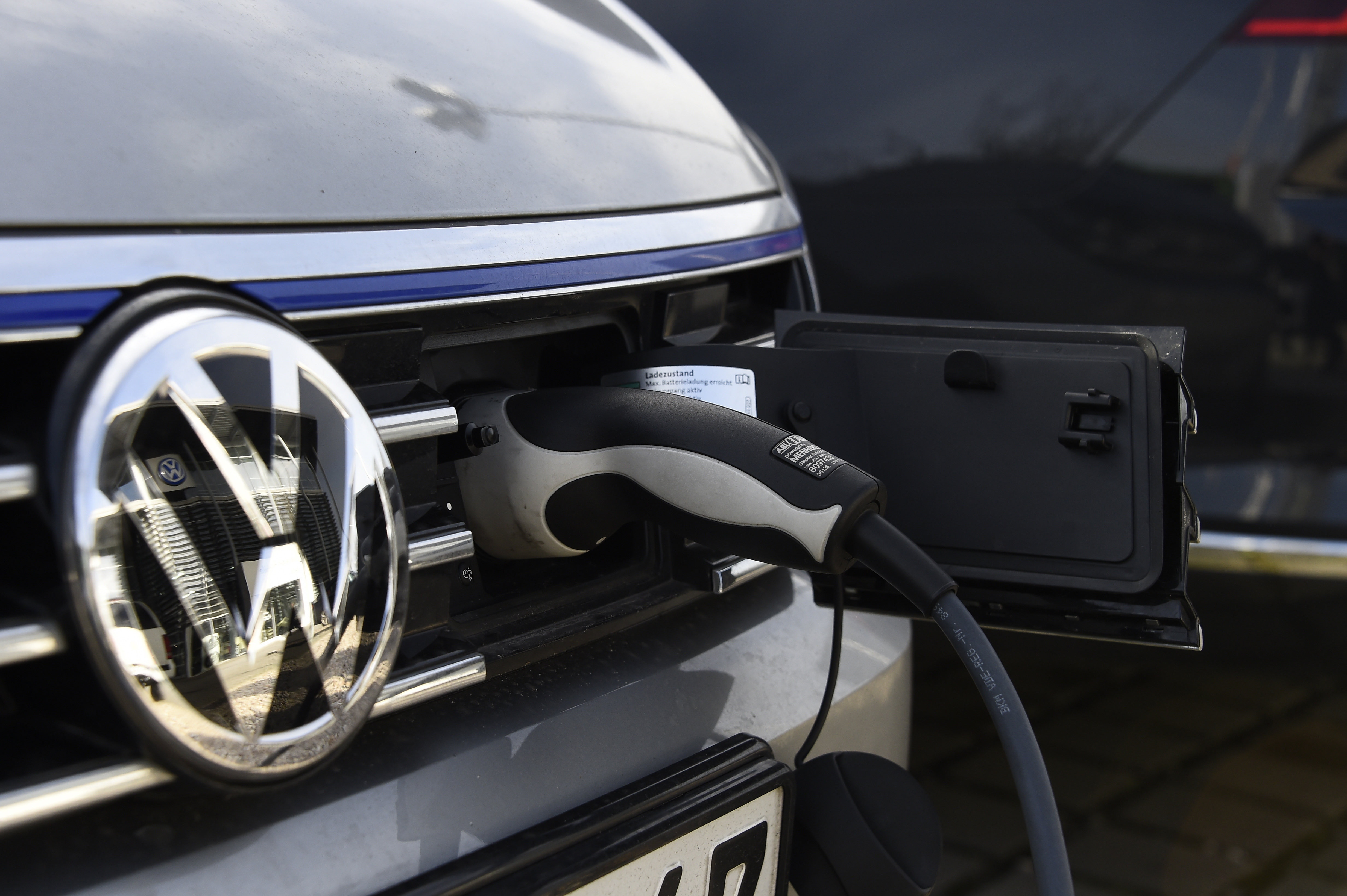 A VW electric car is plugged on a power station at a Service station in Berlin on February 2, 2016. / AFP PHOTO / TOBIAS SCHWARZ