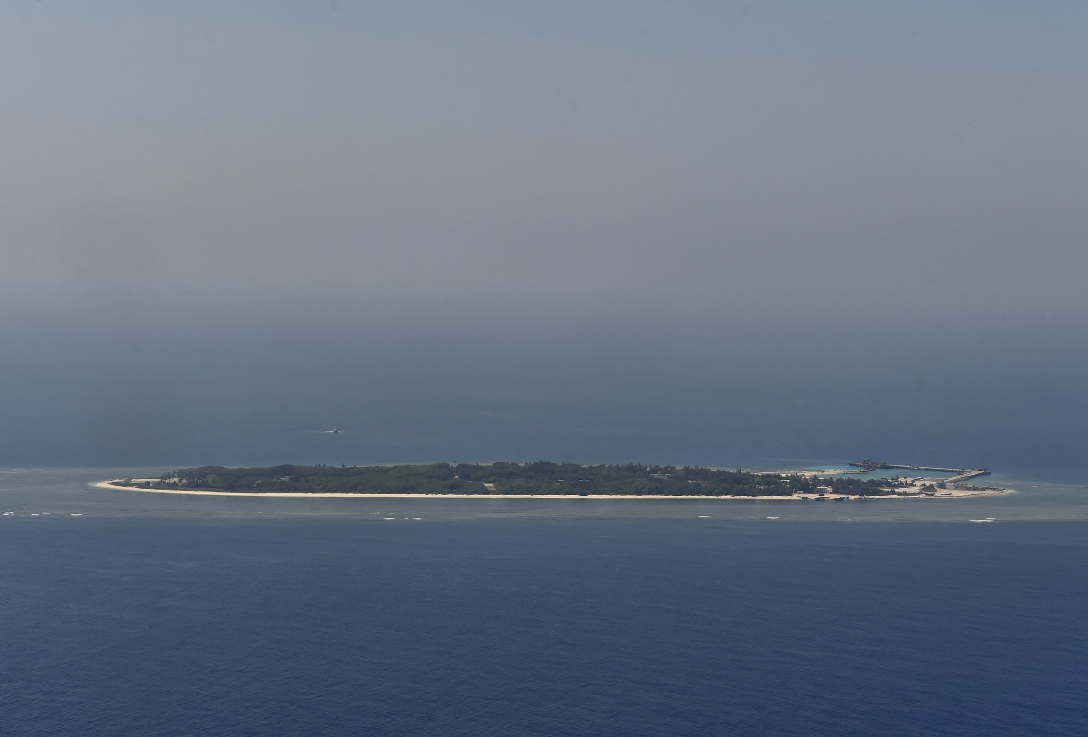 This aerial image taken from a C-130 transport plane shows a general view of Taiping island during a visit by journalists to the island, in the Spratlys chain in the South China Sea on March 23, 2016. Taiwan on March 23 gave its first ever international press tour of a disputed island in the South China Sea to boost its claim, less than two months after a visit by its leader sparked protests from rival claimants. / AFP PHOTO / SAM YEH