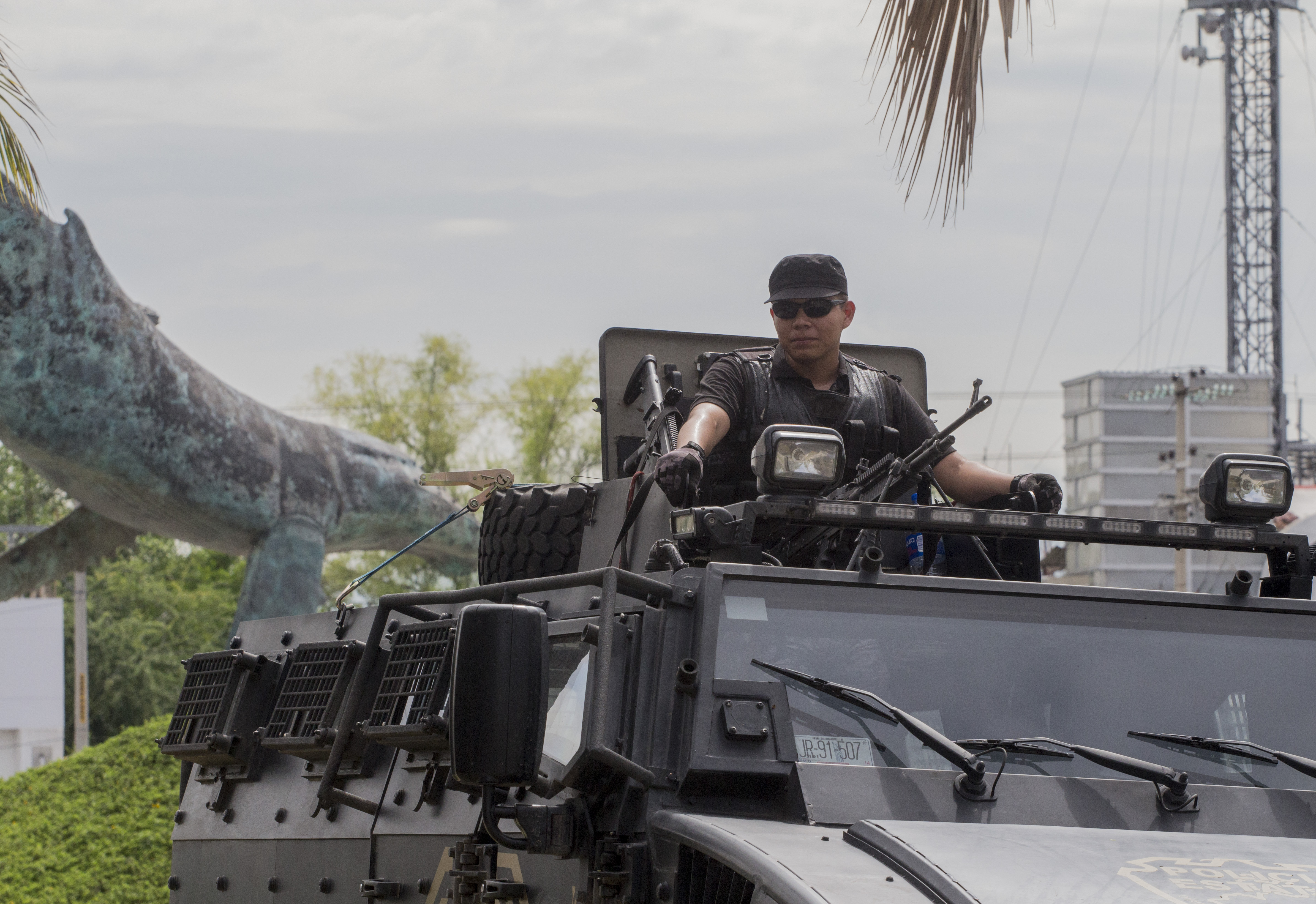 A state police officer patrols a street during a security operation in Puerto Vallarta in the western Mexican state of Jalisco on August 18, 2016.  Jesus Alfredo Guzman Salazar, the son of drug lord Joaquin "El Chapo" Guzman, was among a group kidnapped from a bar in the Mexican resort city of Puerto Vallarta, authorities confirmed Tuesday. Seven gunmen in pickup trucks swooped down on the upscale bar and restaurant Monday around dawn and abducted the victims. Investigators said it was likely part of a settling of scores between rival drug cartels. / AFP PHOTO / HECTOR GUERRERO