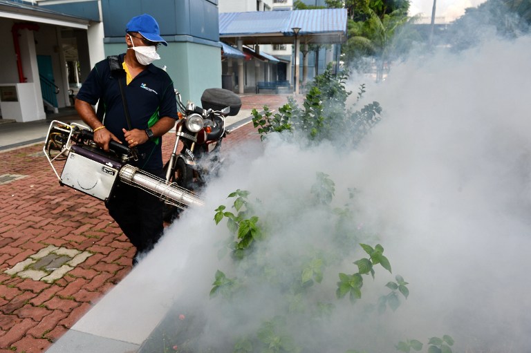 A pest control worker fumigates the grounds of a residential estate in the Bedok North area of Singapore on September 1, 2016.  Singapore's Zika outbreak escalated September 1 after Malaysia said one of its citizens returned infected from the city-state as the government expanded its fumigation drive to a new area identified as a potential cluster for the virus. / AFP PHOTO / ROSLAN RAHMAN