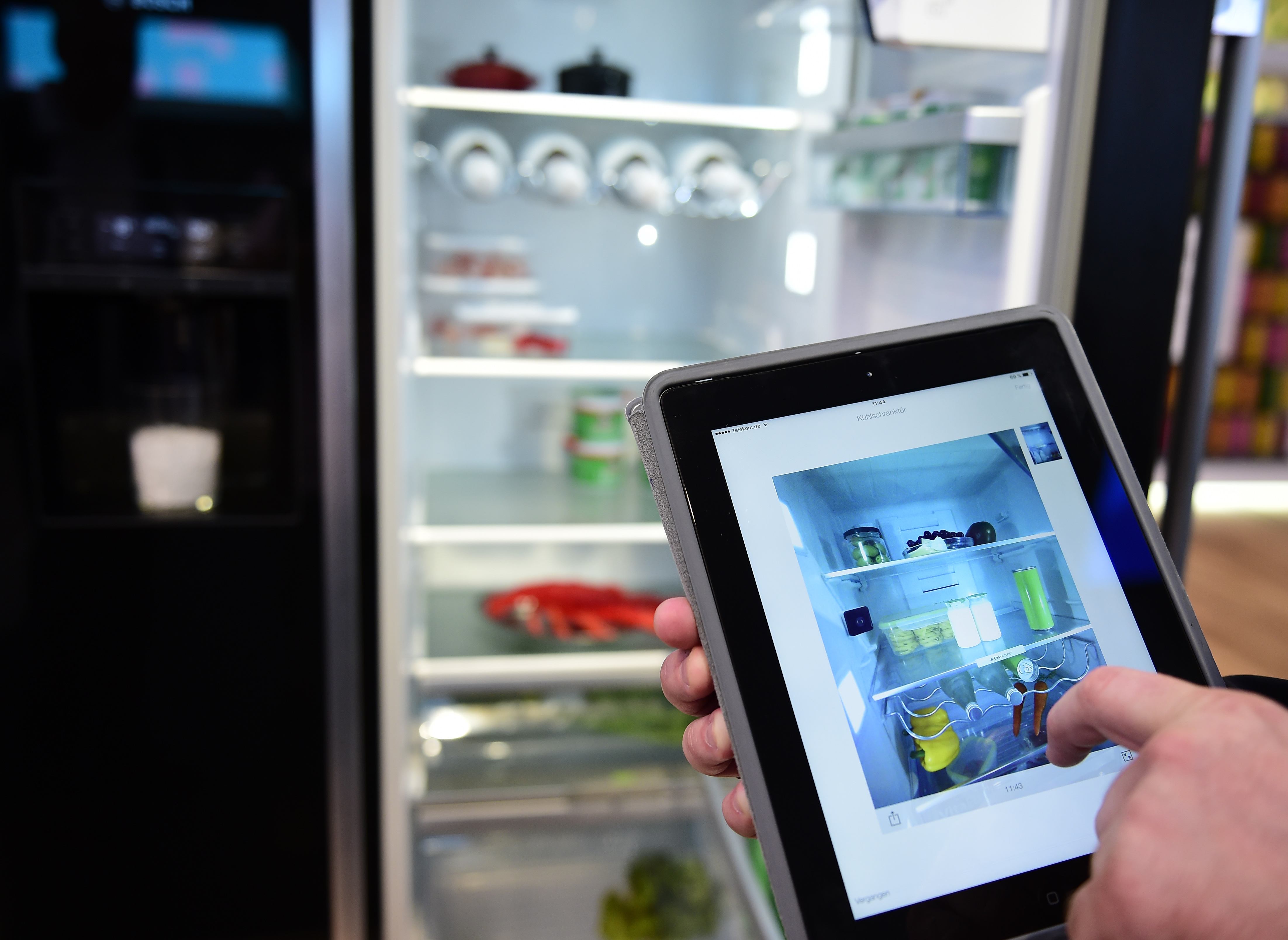 An employee shows the app to control a camera inside a fridge at the booth of Bosch at the IFA (Internationale Funkausstellung) electronics trade fair in Berlin on September 1, 2016.  The IFA is considered the worldwide biggest leading fair for entertainment electronics, IT and household appliances and opens its doors from September 2 till 7. / AFP PHOTO / TOBIAS SCHWARZ