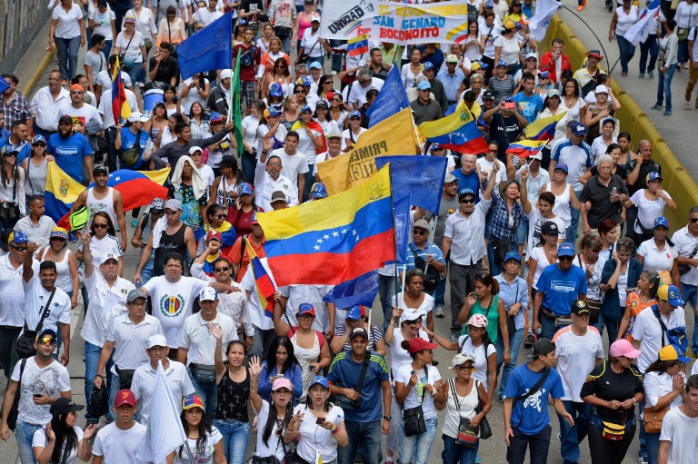 Activists take part in an opposition march in Caracas, on September 1, 2016. Venezuela's opposition and government head into a crucial test of strength Thursday with massive marches for and against a referendum to recall President Nicolas Maduro that have raised fears of a violent confrontation. / AFP PHOTO / FEDERICO PARRA