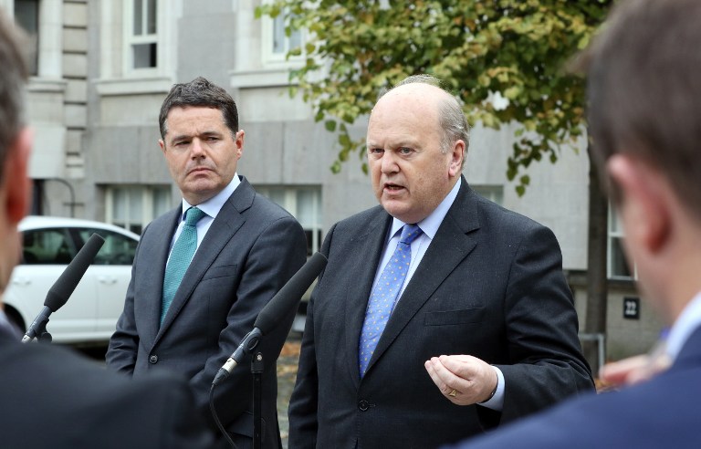 The Minister for Finance, Michael Noonan (R) and the Minister for Public Expenditure and Reform, Paschal Donohoe speak to members of the media in Dublin on September 2, 2016. The Republic of Ireland's cabinet, agreed to appeal the decision on the European Commission's decision that Ireland granted undue tax benefits of up to 13 billion euros ($15 billion) to Apple. / AFP PHOTO / PAUL FAITH