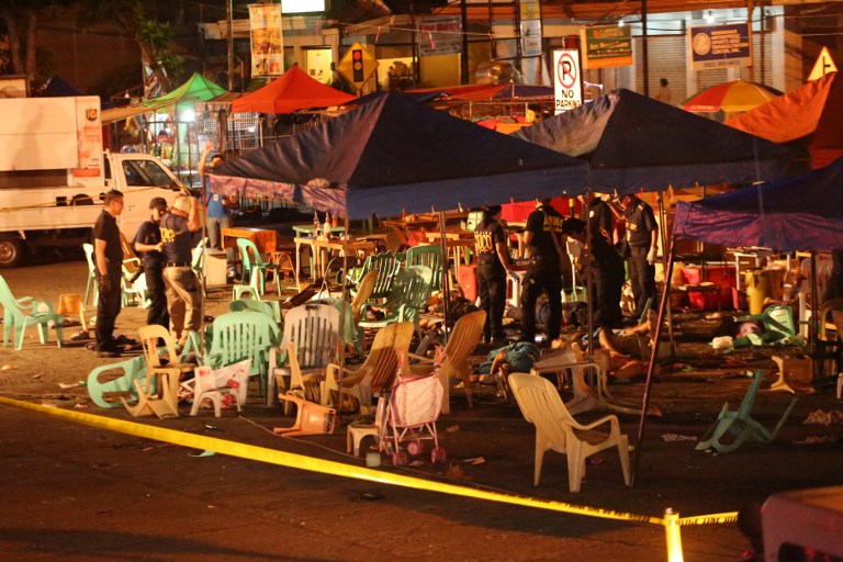 EDITORS NOTE: Graphic content / Police investigators collect evidence through injured and dead people lying on the ground, at the site of an explosion at a night market in Davao City, in southern island of Mindanao, on late September 2, 2016. At least 10 people died and dozens were injured when an explosion rocked Philippine President Rodrigo Duterte's home city of Davao on September 2, 2016 night, police told AFP. The explosion occurred in a bustling part of the city and close to one of its top hotels that is popular with tourists and business people, city spokeswoman Catherine dela Rey said. / AFP PHOTO / MANMAN DEJETO