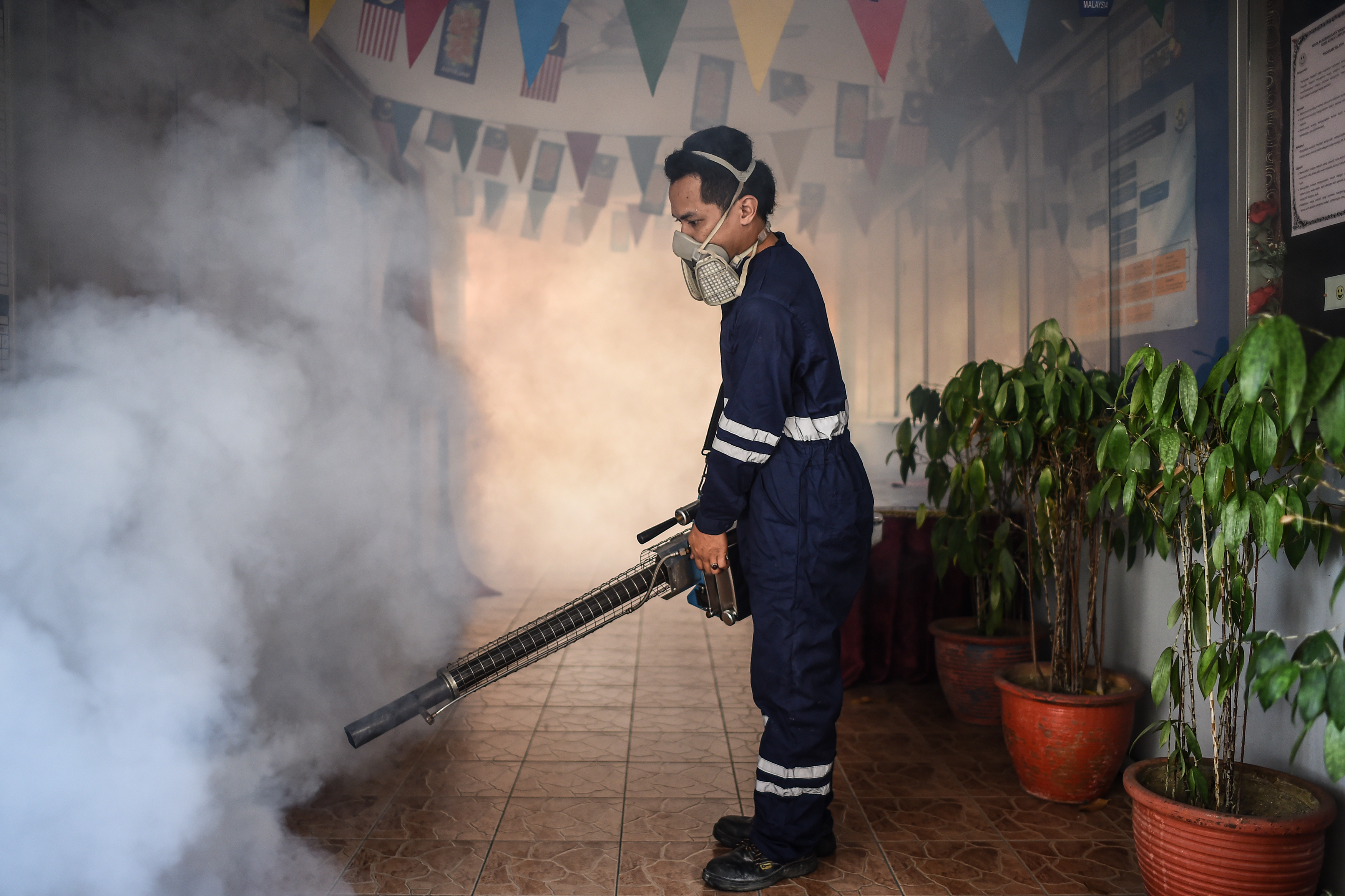 A pest control worker fumigates a school corridor on the eve of the annual national Primary School Evaluation Test in Kuala Lumpur on September 4, 2016.  Malaysia reported its first locally transmitted Zika case on September 3, a 61-year-old man who has died of heart-related complications, the government said. / AFP PHOTO / MOHD RASFAN