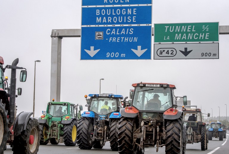 Farmers drive from Loon Plage to Calais, on September 5, 2016, during a joint "go-slow" protest with truck drivers on the A16 highway calling for the dismantling of the so-called "Jungle" migrant camp in the French northern port city of Calais. French farmers and truckers launched a joint operation on September 5, 2016 to block off main routes in and out of Calais to call for the closure of the sprawling "Jungle" migrant camp there. Around 70 trucks began a "go-slow" on the main A16 motorway -- the main artery for freight and passengers heading for Britain either via the Channel Tunnel or the Calais port. / AFP PHOTO / PHILIPPE HUGUEN