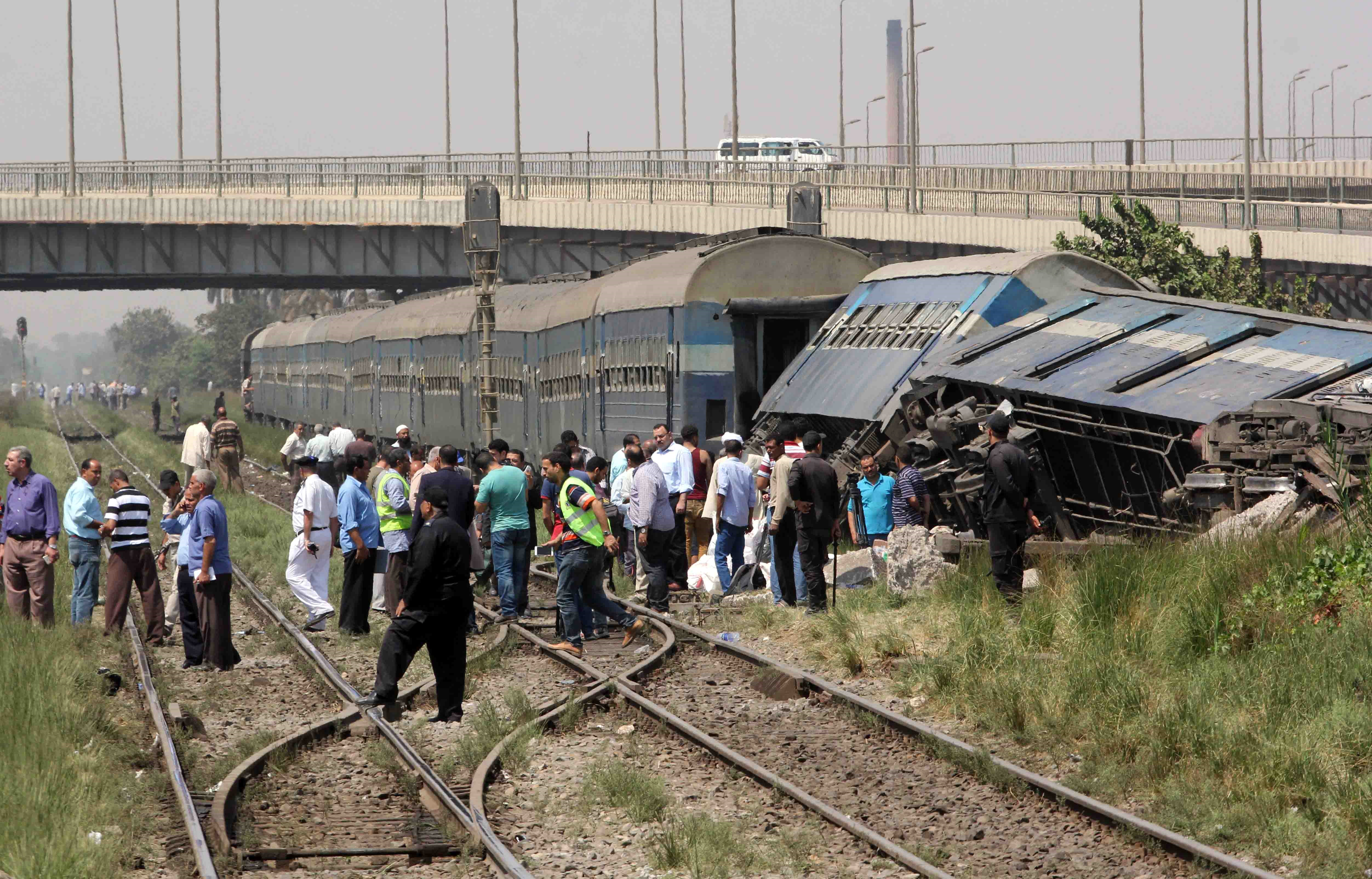 Egyptians check the wreckage of a train after it derailed near the village of Al-Ayyat in Giza on the southern outskirts of the capital Cairo, on September 7, 2016. The conductor suddenly hit the breaks when he spotted a problem with the tracks, causing three carriages to overturn, officials said.  / AFP PHOTO / STRINGER