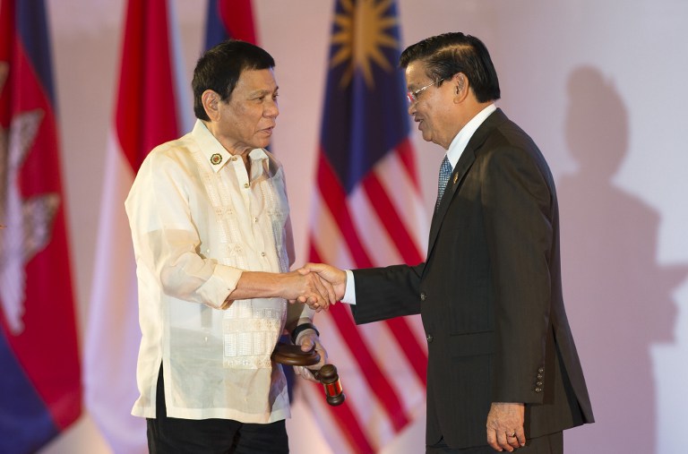 Philippine President Rodrigo Duterte (L) accepts the gavel from Laos Prime Minister Thongloun Sisoulith during the closing ceremony of the Association of Southeast Asian Nations (ASEAN) and handover of the ASEAN Chairmanship to the Philippines in Vientiane on September 8, 2016. ASEAN leaders gather in Vientiane for the 28th and 29th ASEAN Summits held between September 6 to 8. / AFP PHOTO / YE AUNG THU