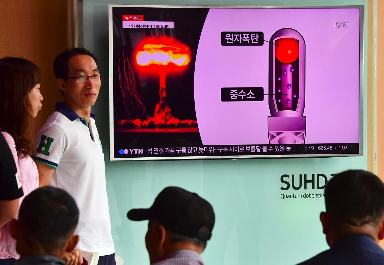 People watch a television news report on North Korea's latest nuclear test at a railway station in Seoul on September 9, 2016. North Korea claimed September 9 it has successfully tested a nuclear warhead that could be mounted on a missile, drawing condemnation from the South over the "maniacal recklessness" of young ruler Kim Jong-Un. / AFP PHOTO / JUNG YEON-JE