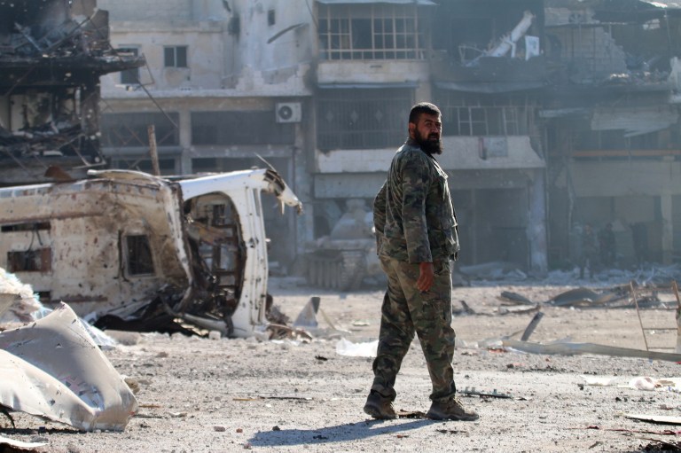 A Syrian pro-regime fighter walks in a bombed-out steet in Ramussa on September 9, 2016, after fellow fighters took control of the strategically important district on the outskirts of the Syrian city of Aleppo the previous day. The government advance in Ramussa has completely closed access routes into Aleppo's rebel-controlled east, under renewed siege by forces loyal to President Bashar al-Assad.  / AFP PHOTO / GEORGE OURFALIAN