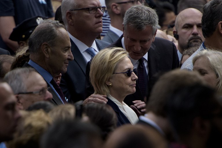 New York City Mayor Bill de Blasio speaks to US Democratic presidential nominee Hillary Clinton during a memorial service at the National 9/11 Memorial September 11, 2016 in New York. The United States on Sunday commemorated the 15th anniversary of the 9/11 attacks. / AFP PHOTO / Brendan Smialowski