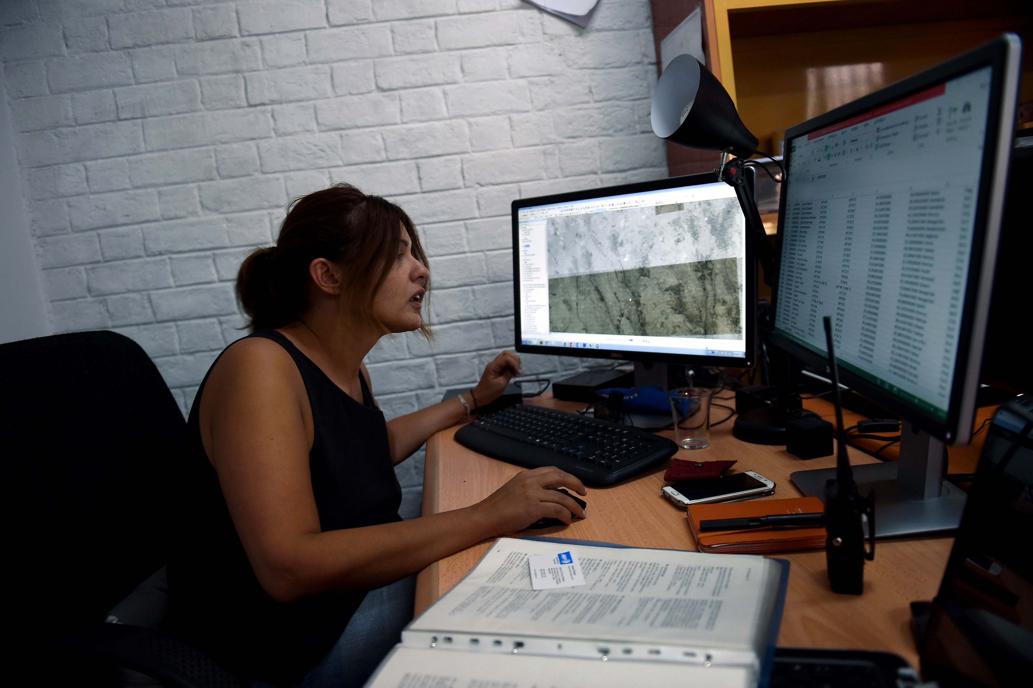 This photo taken on July 18, 2016 shows Elena Leoni, an Italian archaeology specialist on central Asia, looking at her workstation, as she works at the French Archaeological Delegation to Afghanistan (DAFA) office in Kabul. After 30 years of conflicts, Afghanistan's cultural heritage is in dire straits, but one group of archaeologists is trying to put the country's historical sites back on the map - literally. An international team is working to map the country's numerous sites and monuments with satellite imaging into a huge database -- a giant geographic information system (GIS).  / AFP PHOTO / WAKIL KOHSAR / TO GO WITH AFP STORY: Afghanistan-Culture-Archaeology-Heritage / Feature by Anne CHAON