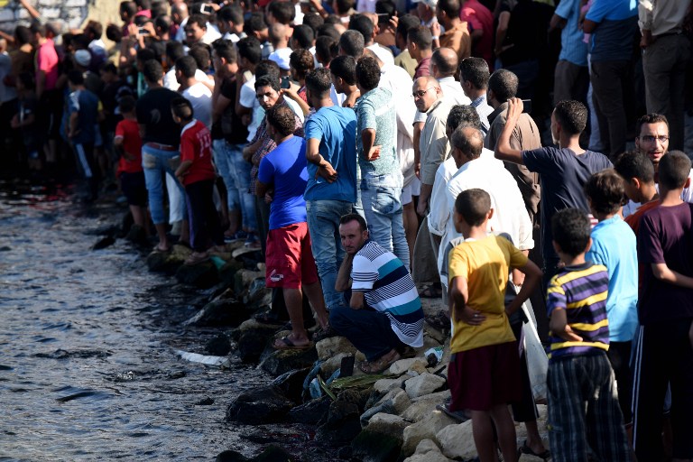 Egyptians stand on the shore as they wait for the recovery of bodies, during a search operation after a boat carrying migrants capsized in the Mediterranean, along the shore in the Egyptian port city of Rosetta on September 21, 2016. A boat carrying up to 450 migrants capsized in the Mediterranean off Egypt's north coast, drowning 42 people and prompting a search operation that rescued 163 passengers, officials said. / AFP PHOTO / MOHAMED EL-SHAHED