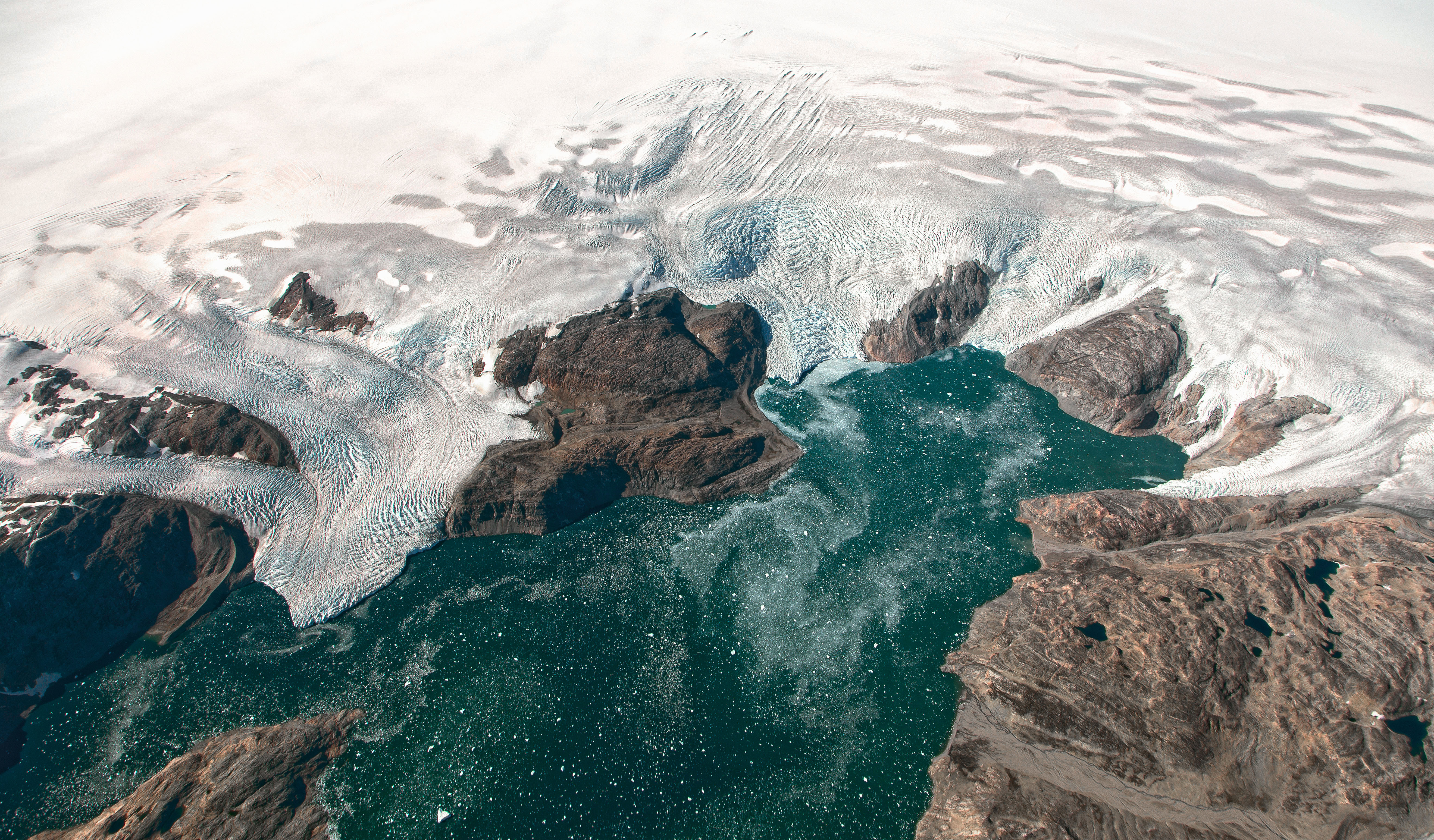 This NASA Earth Observatory image obtained September 22, 2016 show some glaciers observed from the HU-25A Guardian aircraft on September 2, 2016, showing the Brückner and Heim glaciers where they flow into Johan Petersen Fjord in southeastern Greenland. Greenland's highly unstable ice sheet is melting more than seven percent faster than previously thought, scientists said this week after discovering a hotspot beneath the Earth's crust that was distorting their calculations. The study in the journal Science Advances raises concern about the increasing impact of melting ice on sea level rise, since Greenland is the second largest ice sheet in the world after the one in Antarctica. / AFP PHOTO / NASA Goddard / Jeremy HARBECK / RESTRICTED TO EDITORIAL USE - MANDATORY CREDIT "AFP PHOTO / JEREMY HARBECK/NASA GODDARD" - NO MARKETING NO ADVERTISING CAMPAIGNS - DISTRIBUTED AS A SERVICE TO CLIENTS ==TO GO WITH AFP STORY-"Greenland ice melting faster than thought"==