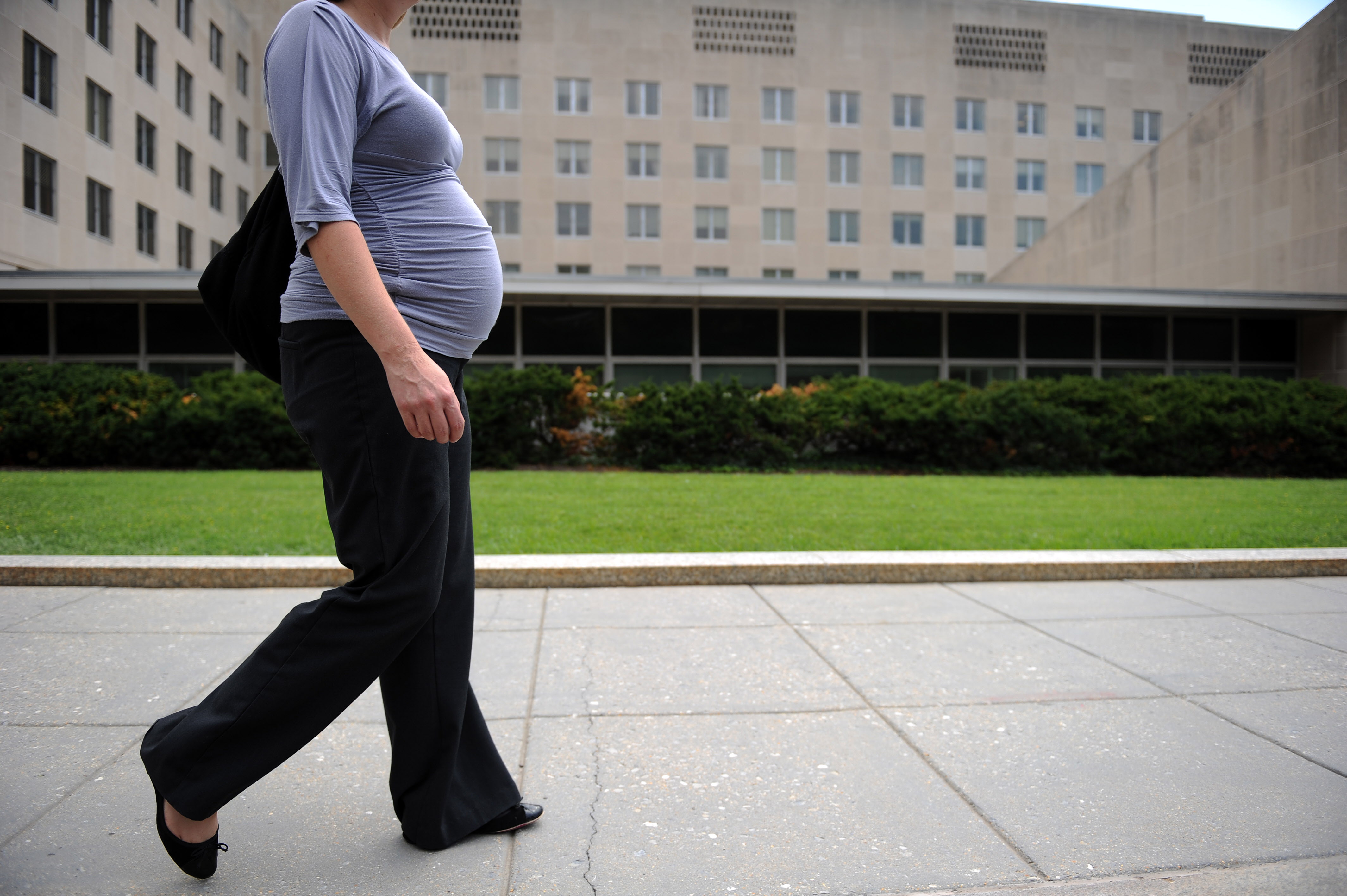 (FILES) This file photo taken on August 5, 2010 shows a pregnant woman walking outside the State Department in Washington, DC.   Morning sickness is linked to a lower risk of miscarriage, according to research out September 26, 2016 that suggests a woman's nausea and vomiting early in pregnancy may have protective effects for the fetus.Between 50 and 80 percent of pregnant women report feeling nauseous or throwing up during their first trimester, said the findings in the Journal of the American Medical Association (JAMA) Internal Medicine.  / AFP PHOTO / Timothy SLOAN
