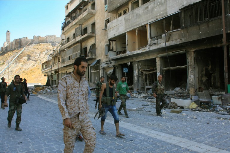 Syrian pro-government forces are seen on September 28, 2016 in the Farafira district, northwest of Aleppo's historic citadel, after Syria's army took control of the rebel-held district after days of heavy air strikes that have killed dozens and sparked allegations of war crimes.  / AFP PHOTO / GEORGES OURFALIAN