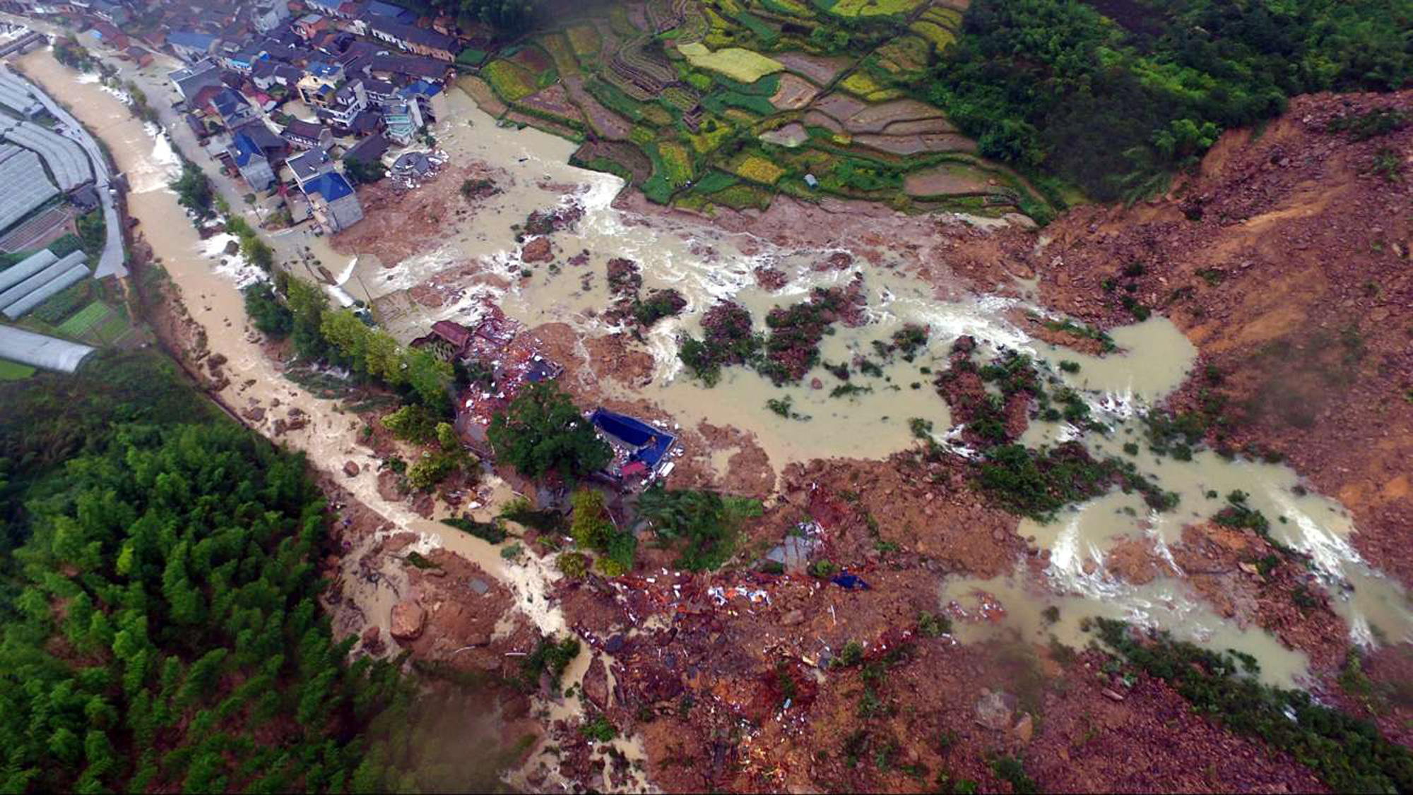 This aerial photo taken on September 29, 2016 shows Chinese rescuers searching for survivors at a landslide area in the village of Sucun in Suichang county, east China's Zhejiang province. A landslide which hit a village in eastern China on September 28 buried dozens of houses and left 27 people missing, state media reported. / AFP PHOTO / STR / China OUT