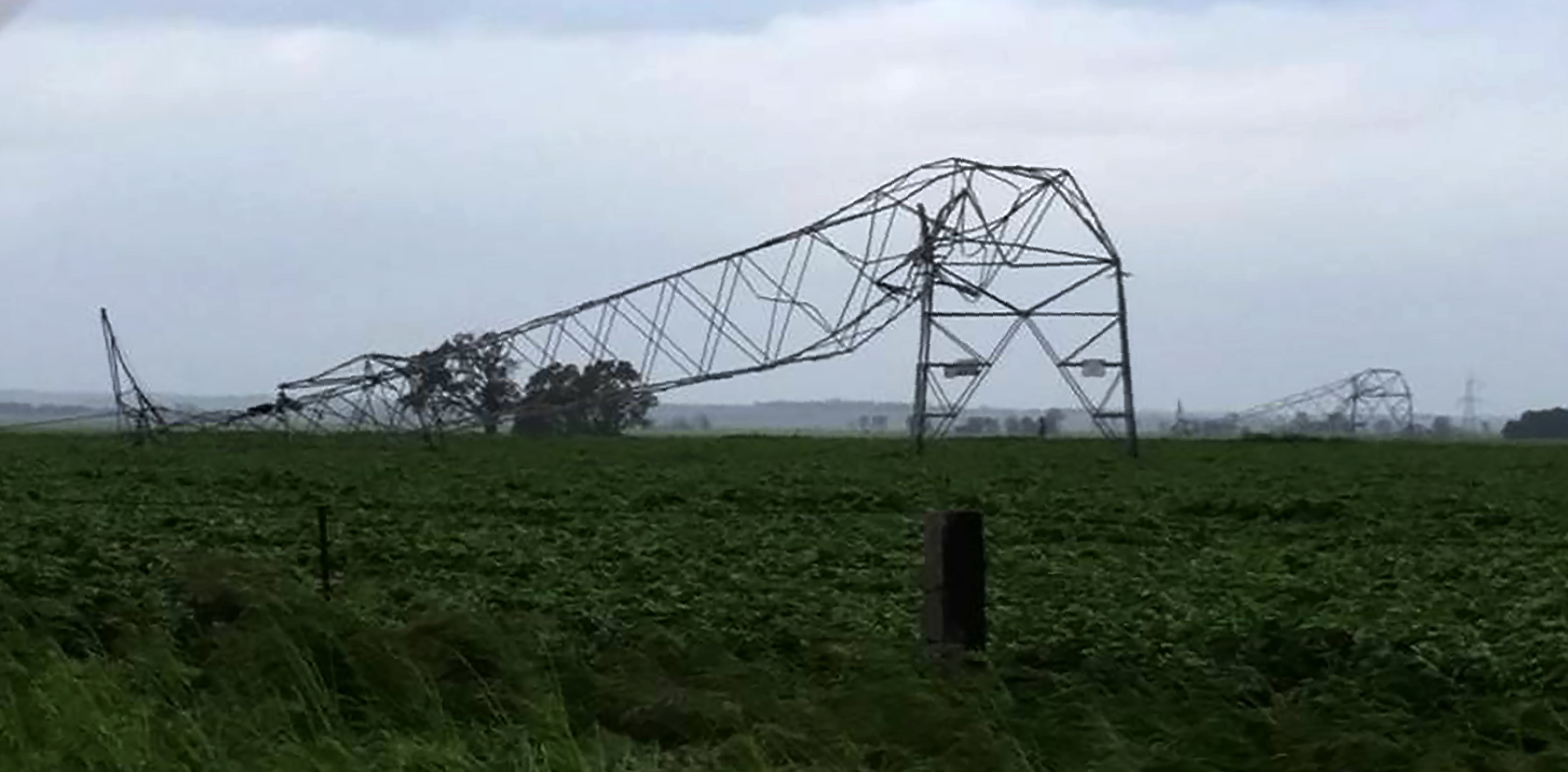 A photo taken on September 28 and obtained on September 29, 2016, shows transmission towers carrying power lines, toppled by high winds near Melrose in South Australia. Australia on Thursday after "unprecedented" thunderstorms knocked out supply to the entire population. The blackout caused chaos and widespread damage was reported as authorities warned of more wild weather to come. / AFP PHOTO / DEBBIE PROSSER / DEBBIE PROSSER