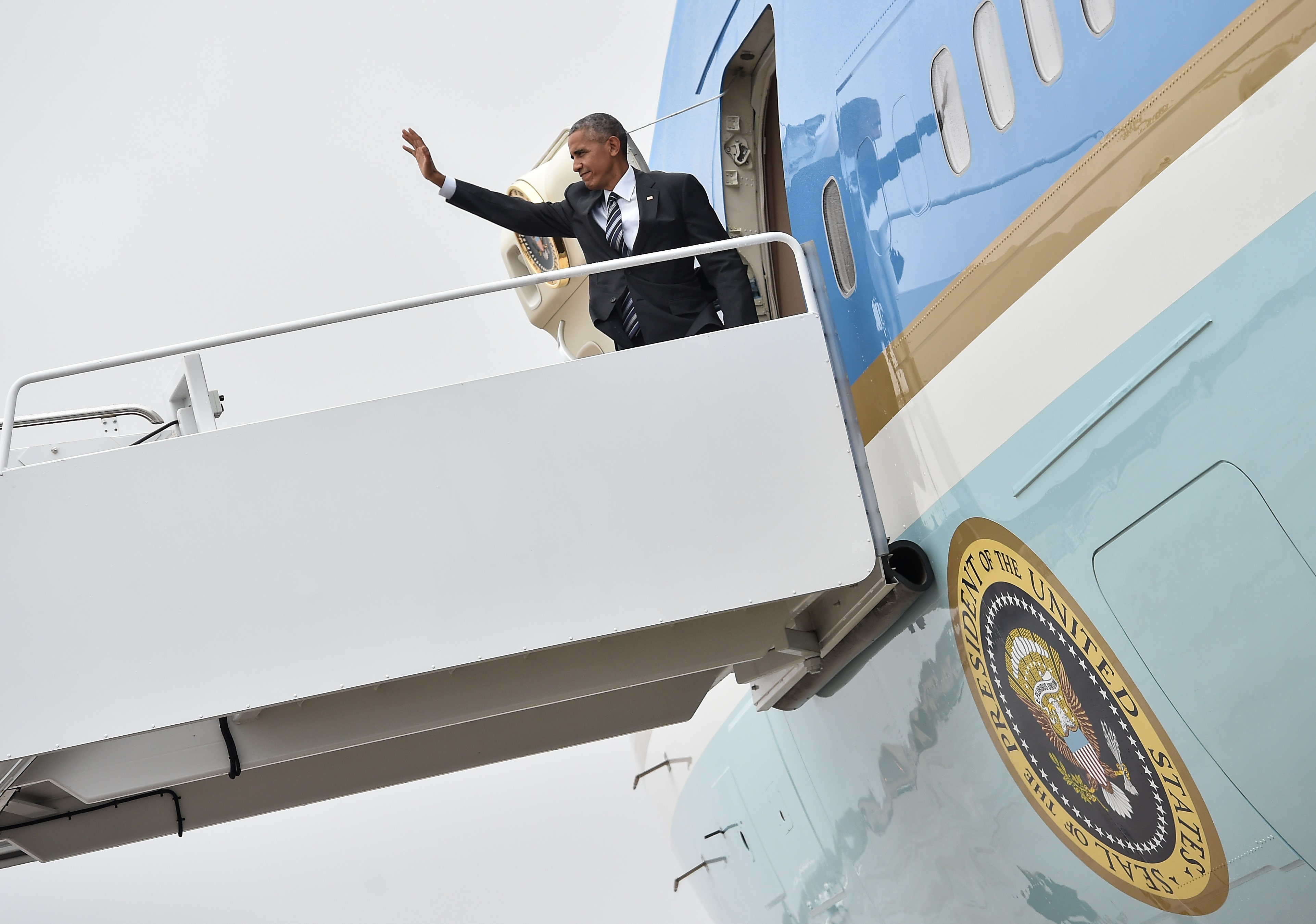 US President Barack Obama waves upon boarding Air Force One at Andrews Air Force Base in Maryland on September 29, 2016 as he departs to attend the funeral of former Israeli president Shimon Peres in Jerusalem. World leaders from Obama to Prince Charles are expected in Israel to attend the funeral of Peres. / AFP PHOTO / NICHOLAS KAMM