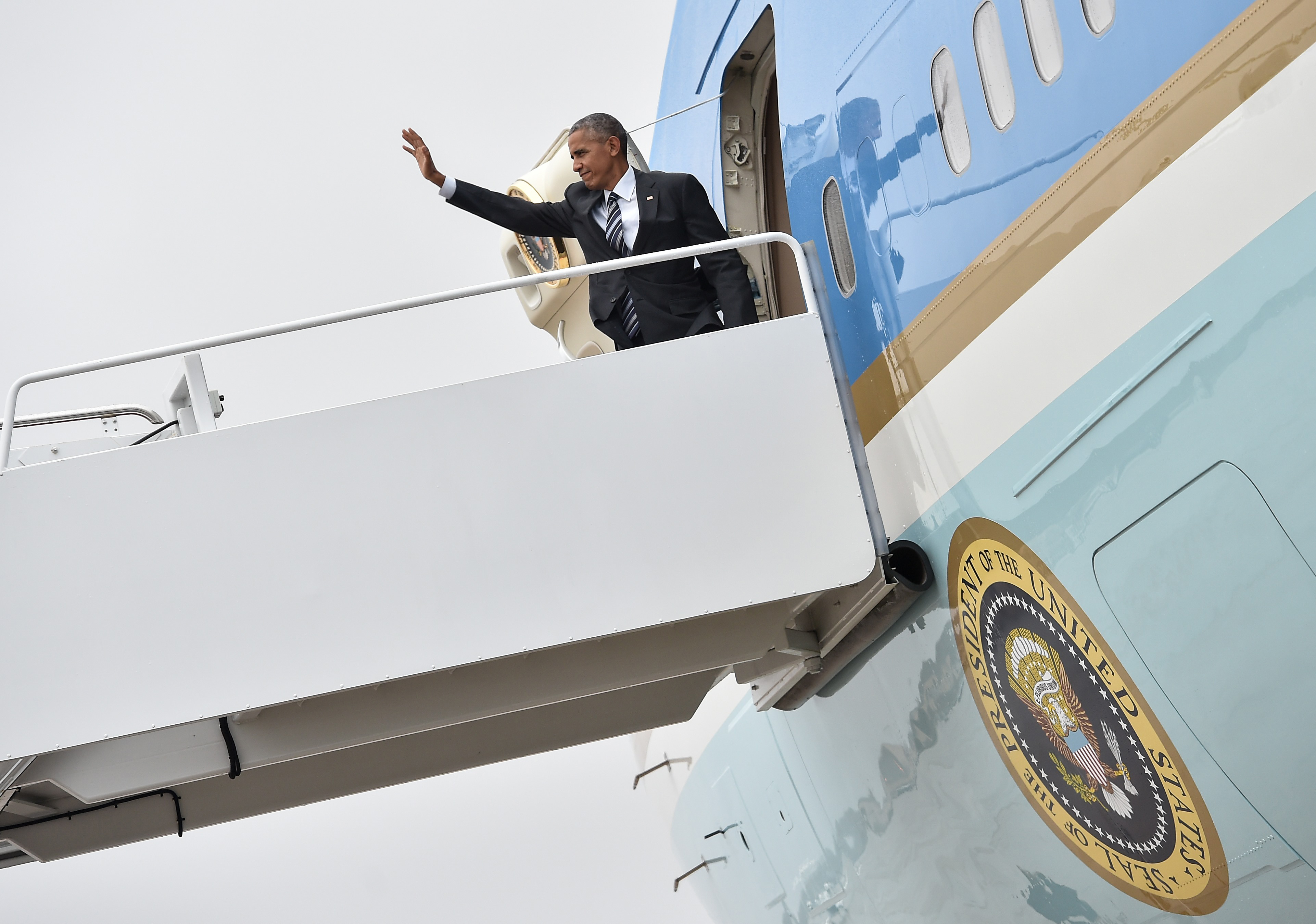 US President Barack Obama waves upon boarding Air Force One at Andrews Air Force Base in Maryland on September 29, 2016 as he departs to attend the funeral of former Israeli president Shimon Peres in Jerusalem. World leaders from Obama to Prince Charles are expected in Israel to attend the funeral of Peres.  / AFP PHOTO / NICHOLAS KAMM