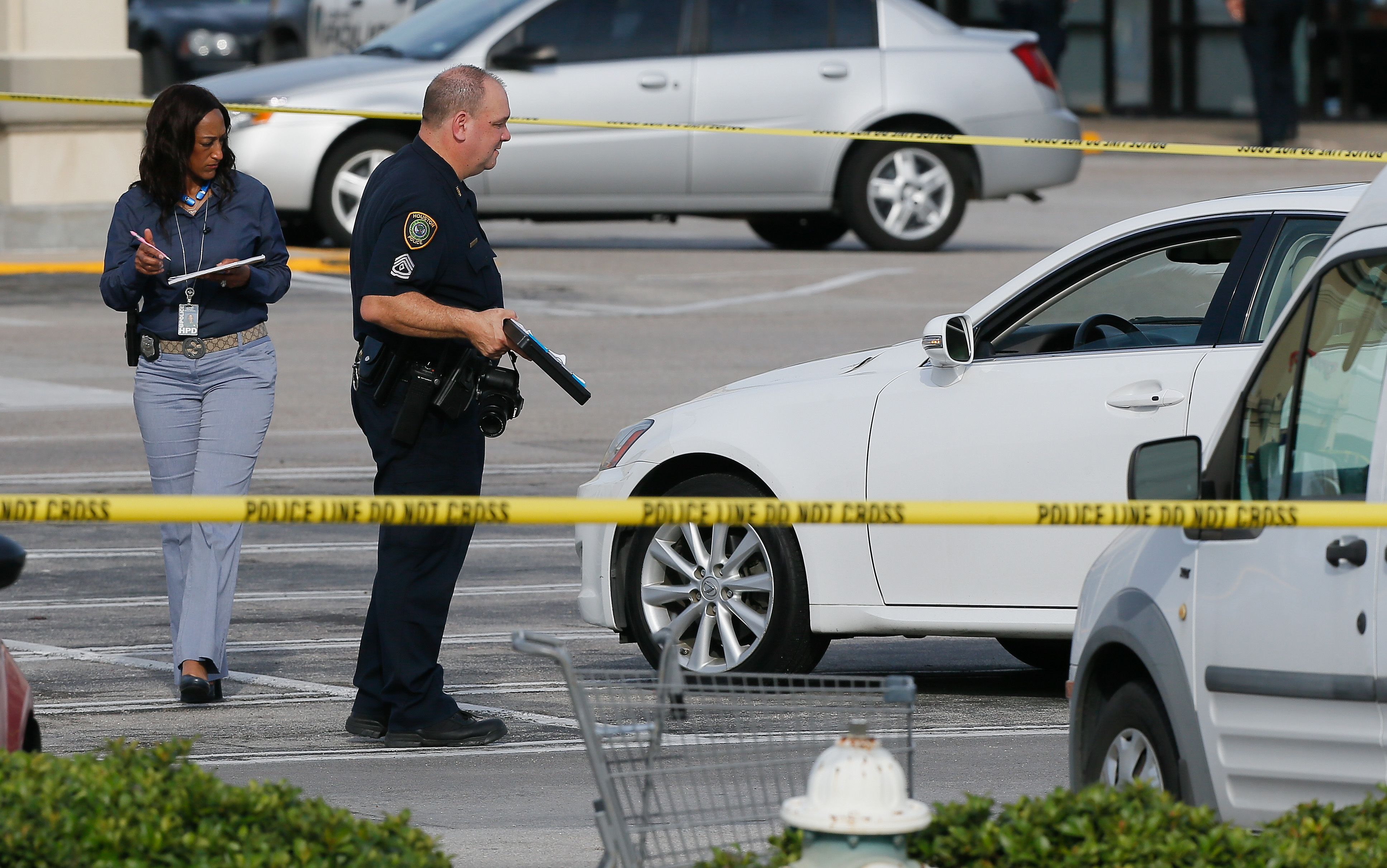 HOUSTON, TX - SEPTEMBER 26: Houston Police investigators photograph a vehicle that received gunshot damage during a scene where nine people were wounded in a strip mall shooting on September 26, 2016 in Houston, Texas. The gunman was shot and killed by police officers. Three victims have been transported to Southwest Memorial Hospital, one has been taken to Ben Taub General Hospital and two have been transported to Memorial Hermann - Texas Medical Center.   Bob Levey/Getty Images/AFP