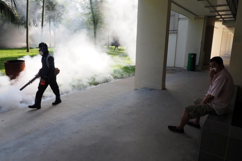 A resident shields his nose as pest control officer carry out fogging in the Aljunied Crescent cluster in Singapore, September 3, 2016 in this photo taken by Antara Foto. Antara Foto/MN Kanwa/via REUTERS