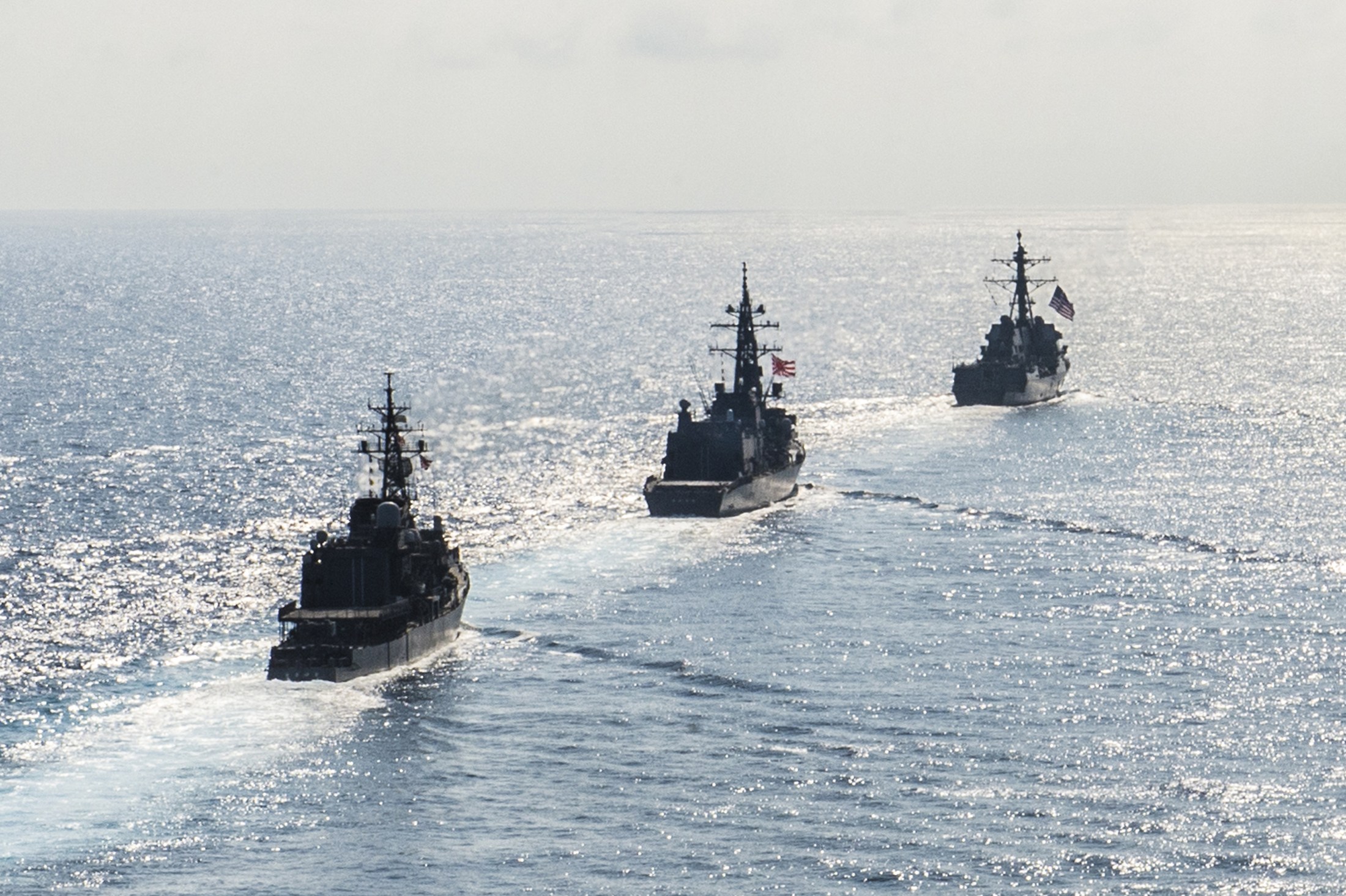 FILE PHOTO - Arleigh Burke-class guided-missile destroyer USS Mustin (DDG 89) transits in formation with Japan Maritime Self-Defense Force ships JS Kirisame (DD 104) and JS Asayuki (DD 132) during bilateral training in South China Sea on April 21, 2015. Courtesy David Flewellyn/U.S. Navy/Handout via REUTERS