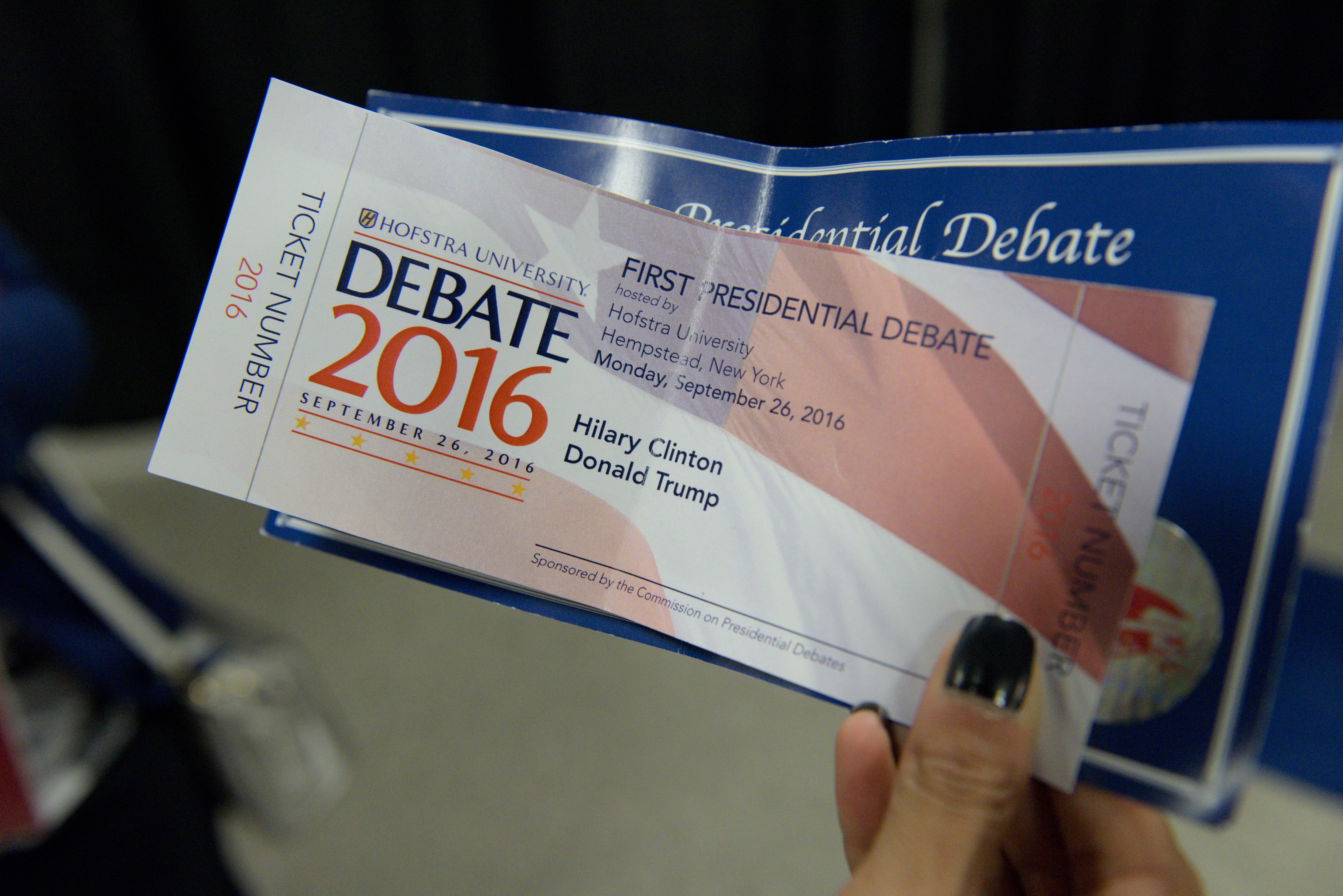 A woman holds a Presidential debate ticket with the name "Hilary" misspelled during the first presidential debate at Hofstra University in Hempstead, New York on September 26, 2016. The first US presidential debate, between Democratic candidate Hillary Clinton and Republican Donald Trump, is one of the high points of the campaign, six weeks from the November 8 elections. / AFP PHOTO / Brendan SMIALOWSKI