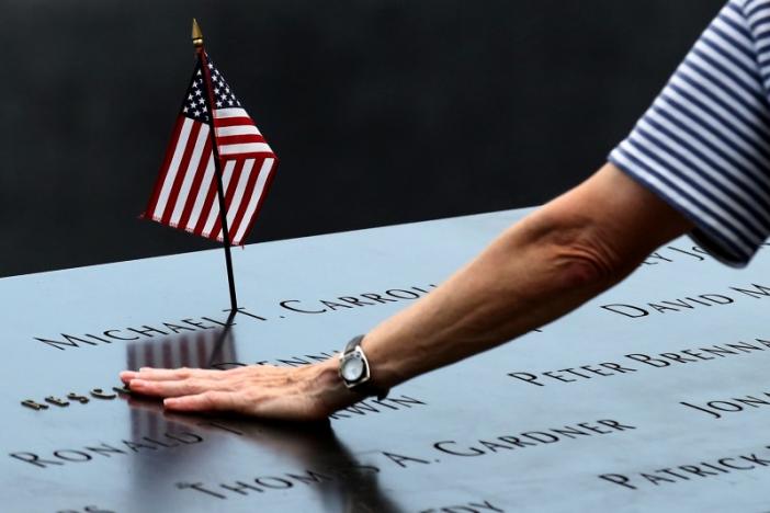 A woman places her hand over a name on the memorial at the National September 11 Memorial and Museum in Lower Manhattan in New York City, U.S., September 9, 2016. REUTERS/Brendan McDermid