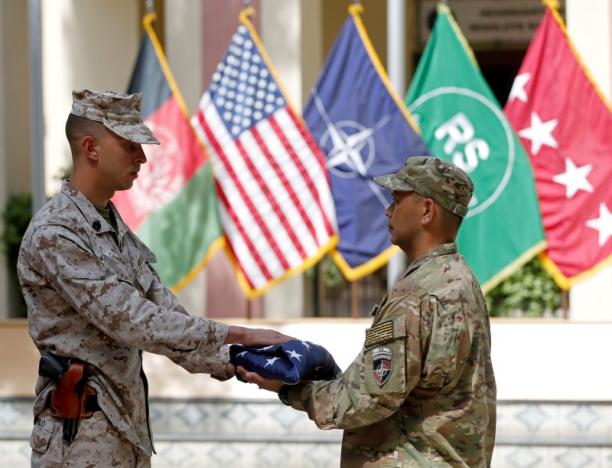 U.S. soldiers hand over the flag during a memorial ceremony to commemorate the 15th anniversary of the 9/11 attacks, in Kabul, Afghanistan September 11, 2016. REUTERS/Omar Sobhani