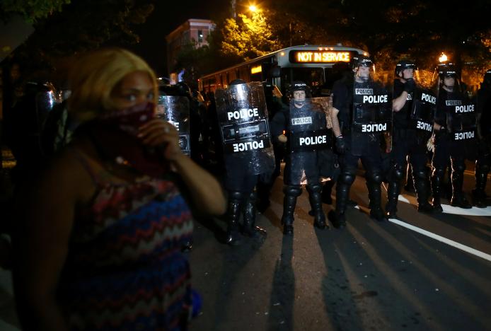 A demonstrator is greeted by police in riot gear while continuing to protest after curfew in Charlotte, North Carolina, U.S., September 25, 2016. REUTERS/Mike Blake