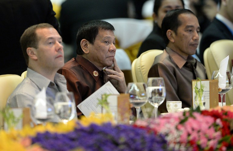Philippine President Rodrigo Duterte (C) sits beside Russian Prime Minister Dmitry Medvedev (L) and Indonesia's President Joko Widodo at the gala dinner during the second day of the Association of Southeast Asian Nations (ASEAN) Summit in Vientiane on September 7, 2016. The gathering will see the 10 ASEAN members meet by themselves, then with leaders from the US, Japan, South Korea and China. / AFP PHOTO / NOEL CELIS